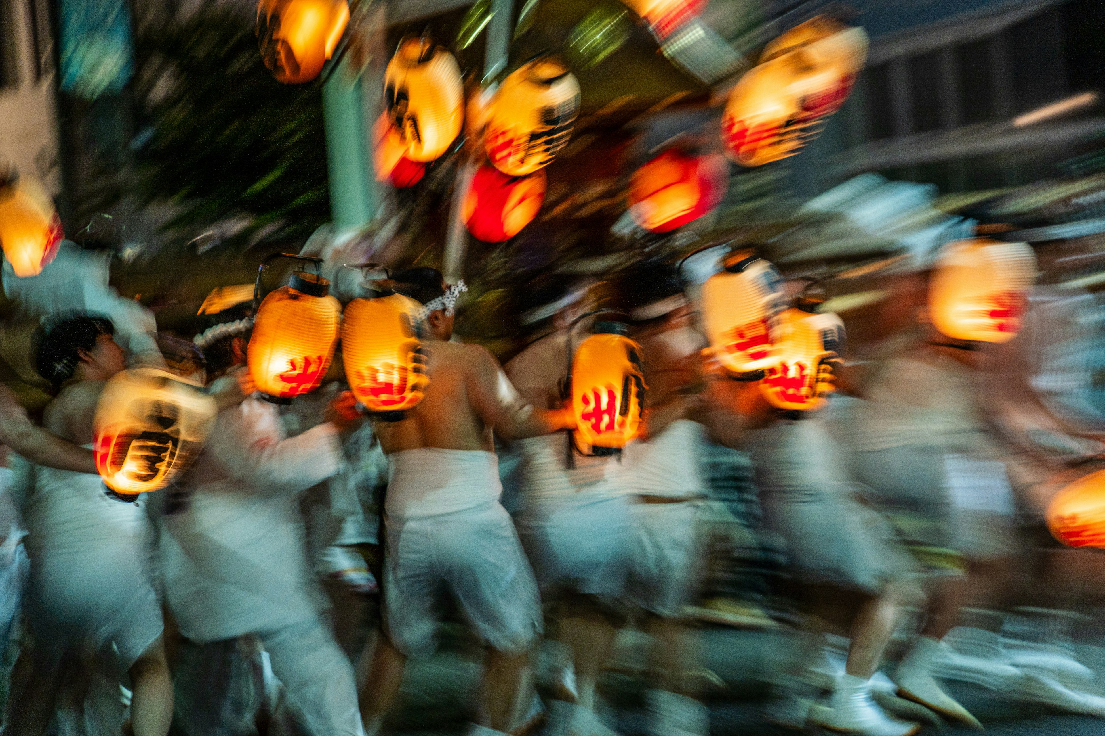 Movimiento borroso de personas sosteniendo linternas durante un festival nocturno