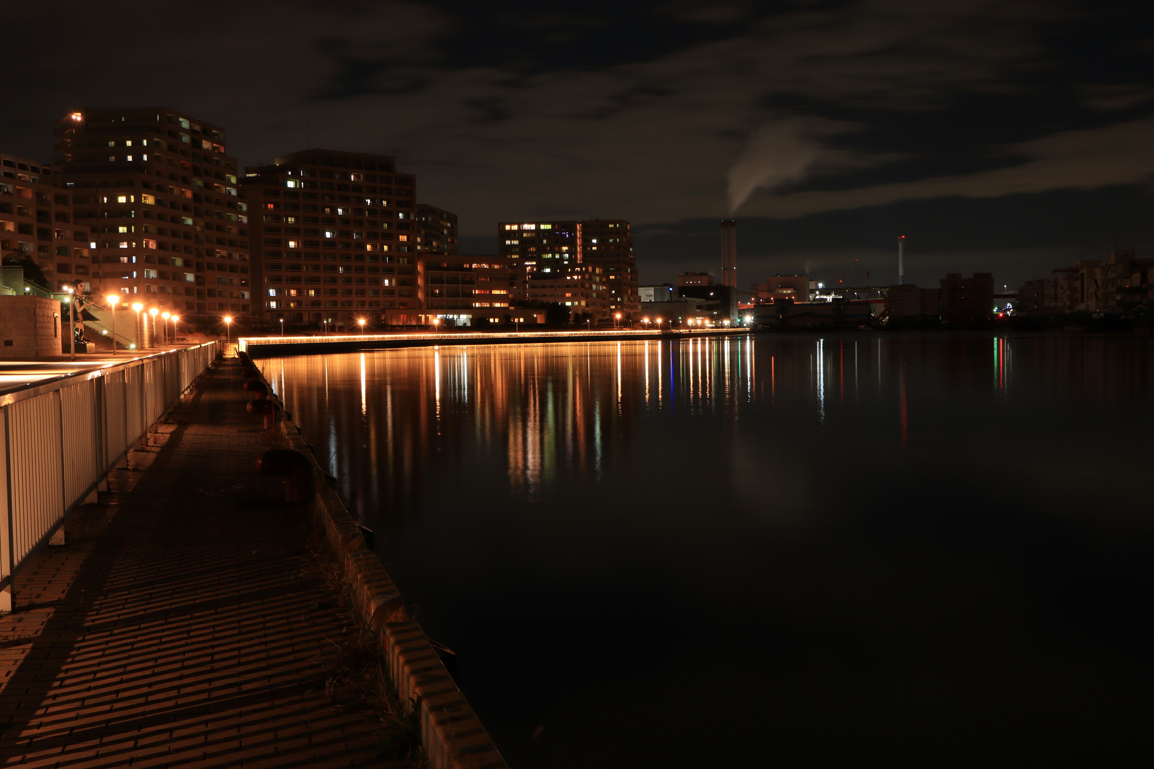 Night cityscape with reflections on water and illuminated buildings