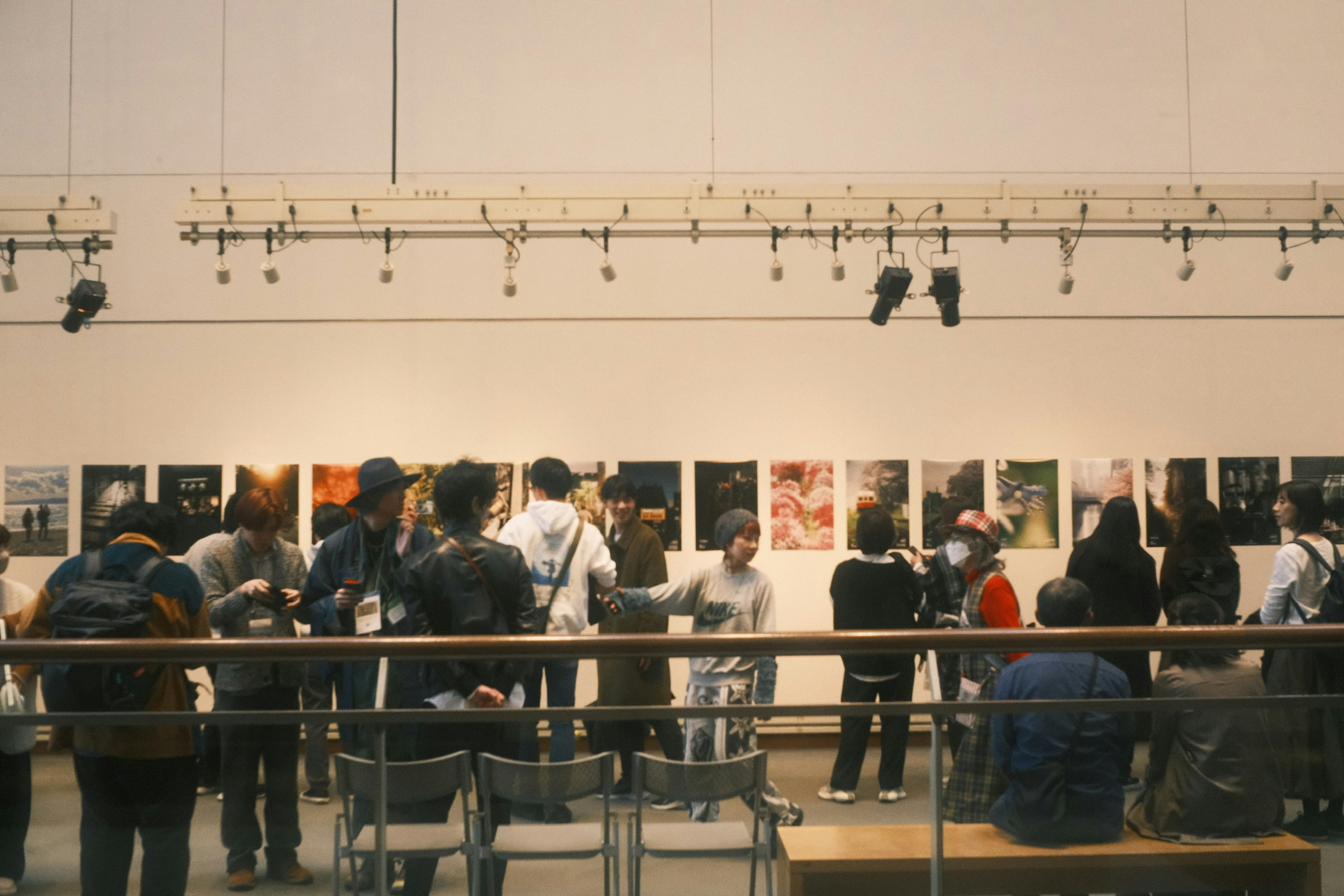 Visitantes observando obras fotográficas en una galería de arte de diseño moderno