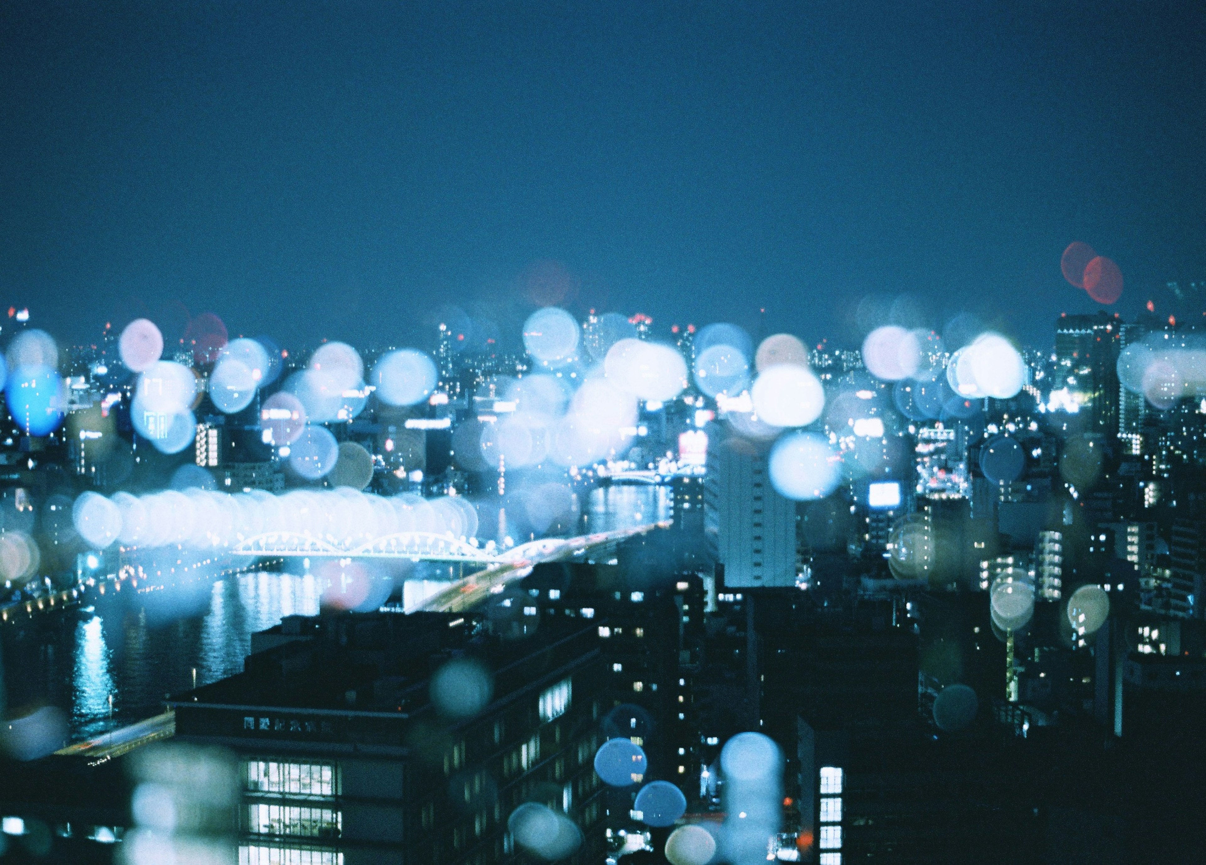 Blurred city lights at night with reflections on water