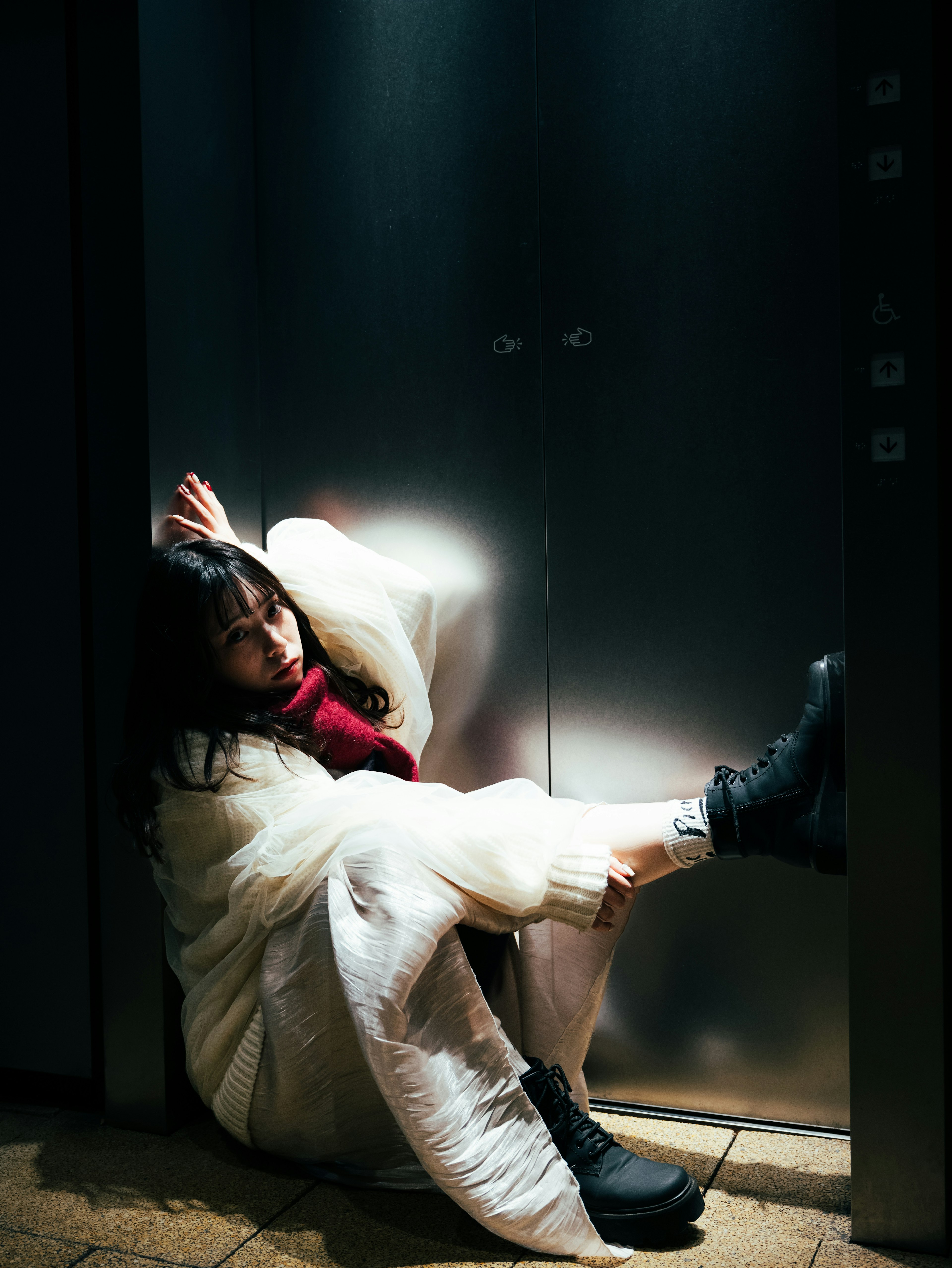 A woman in a white coat sitting in an elevator