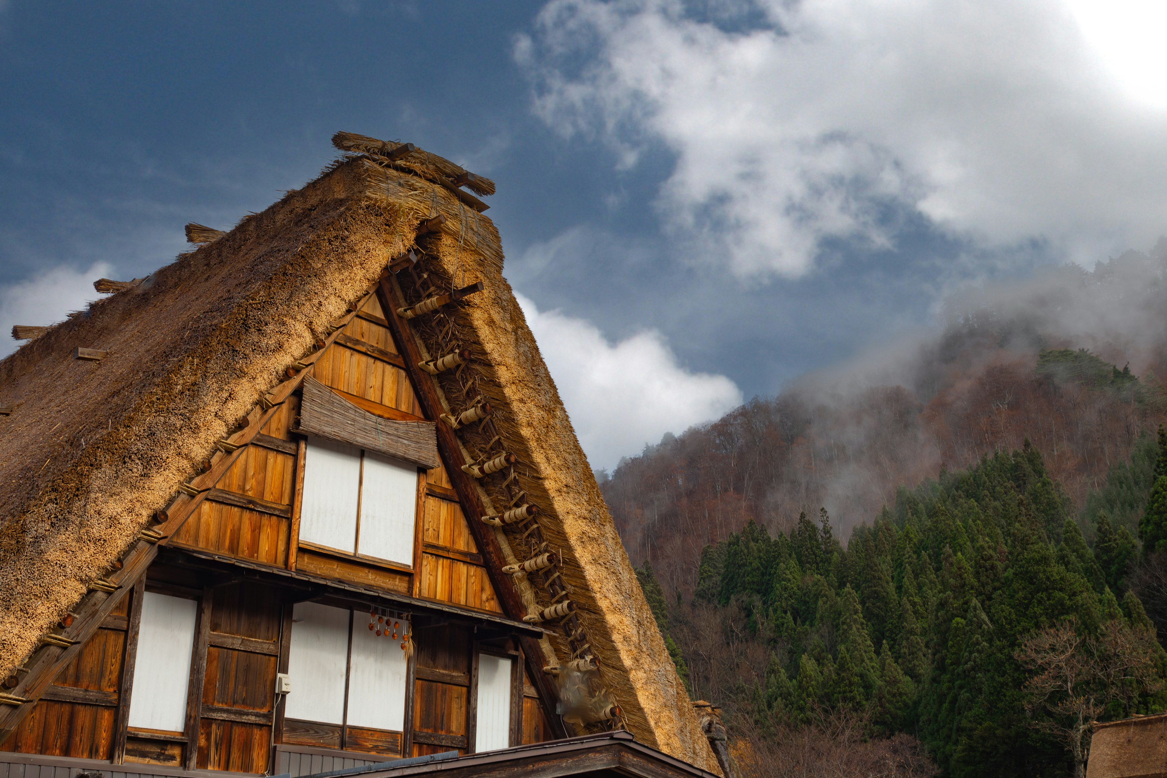 Traditional gassho-zukuri house with mountain backdrop