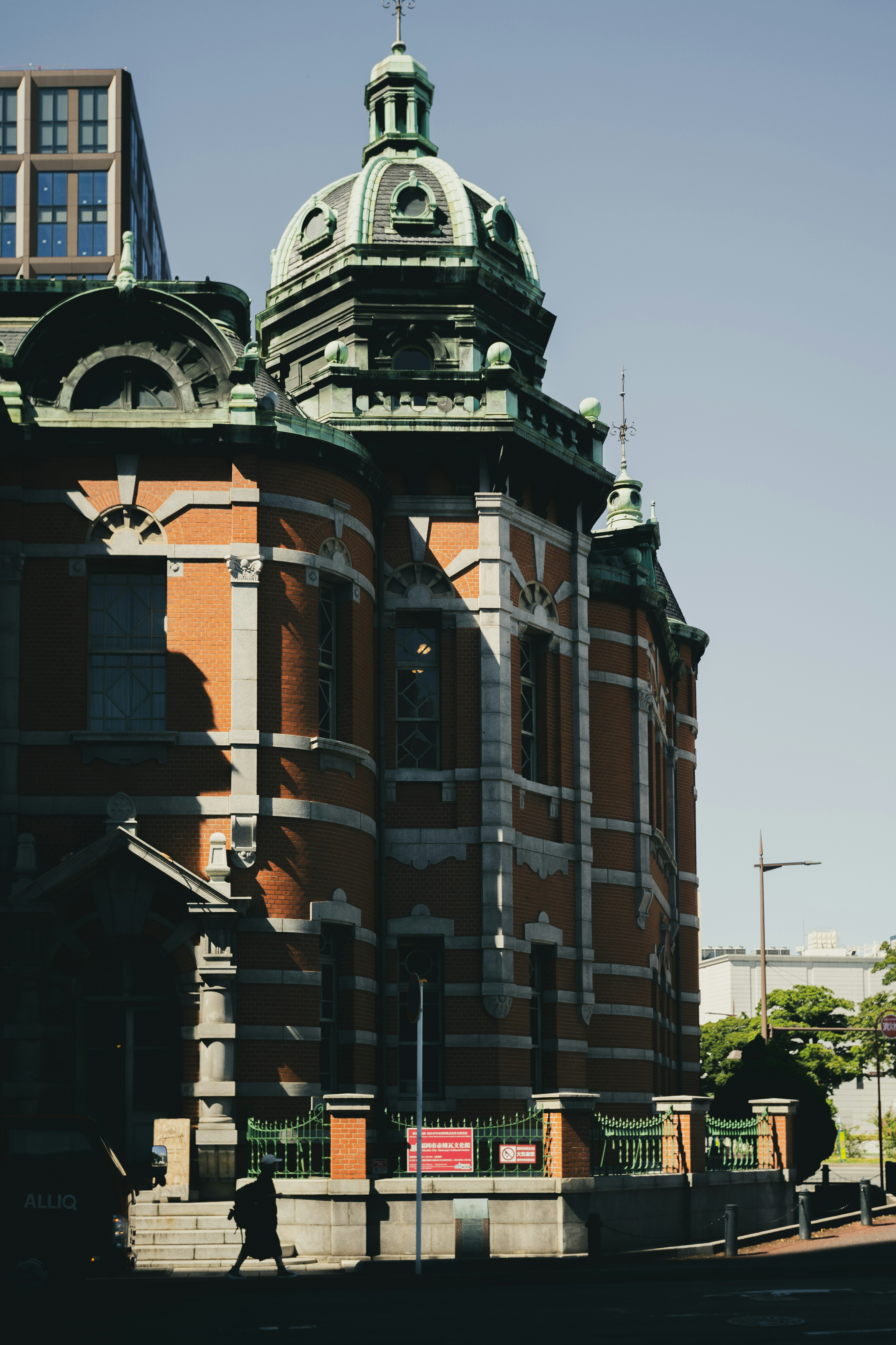 Historic building featuring red brick and a green dome roof