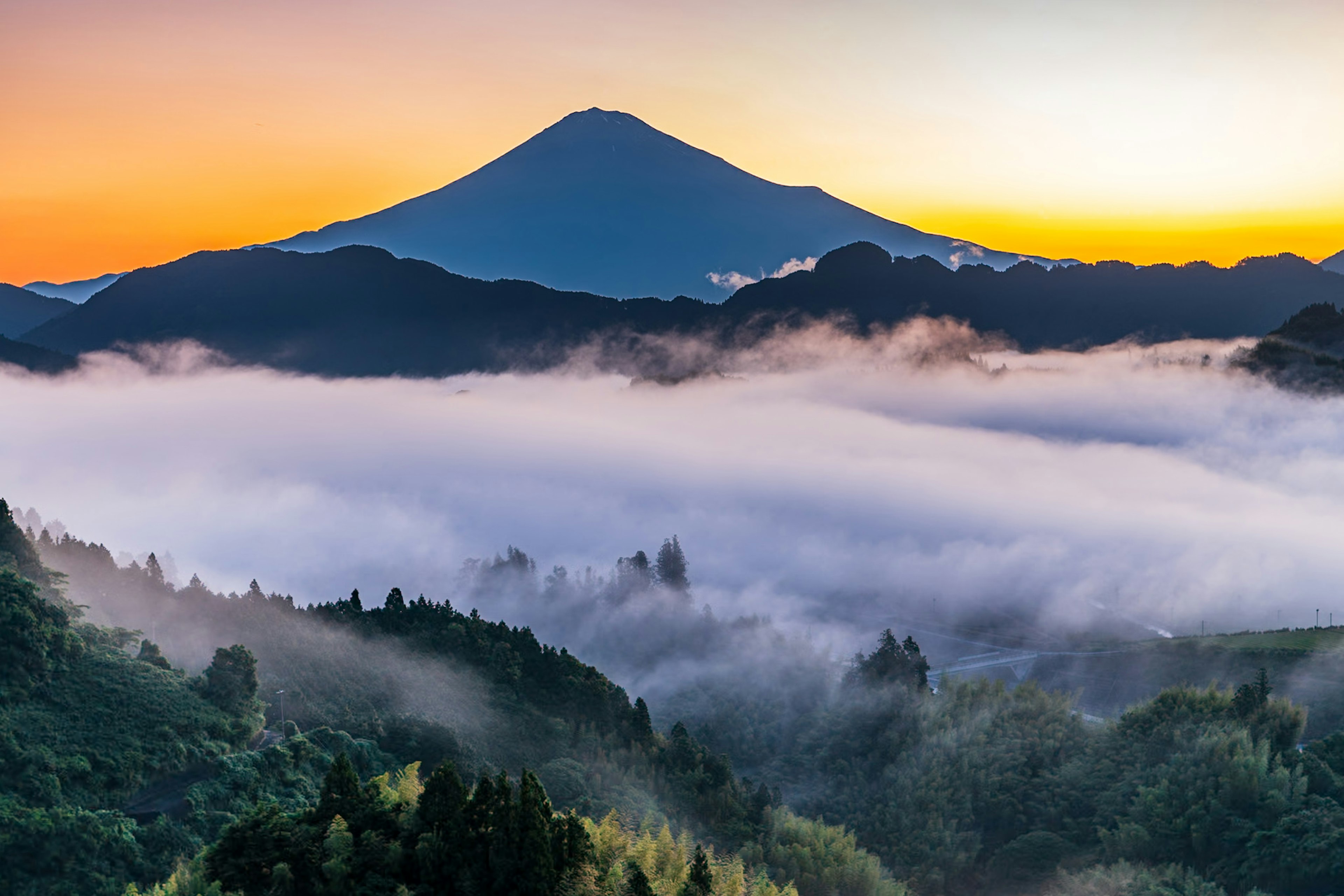 Monte Fuji circondato da nuvole al tramonto con colori vivaci