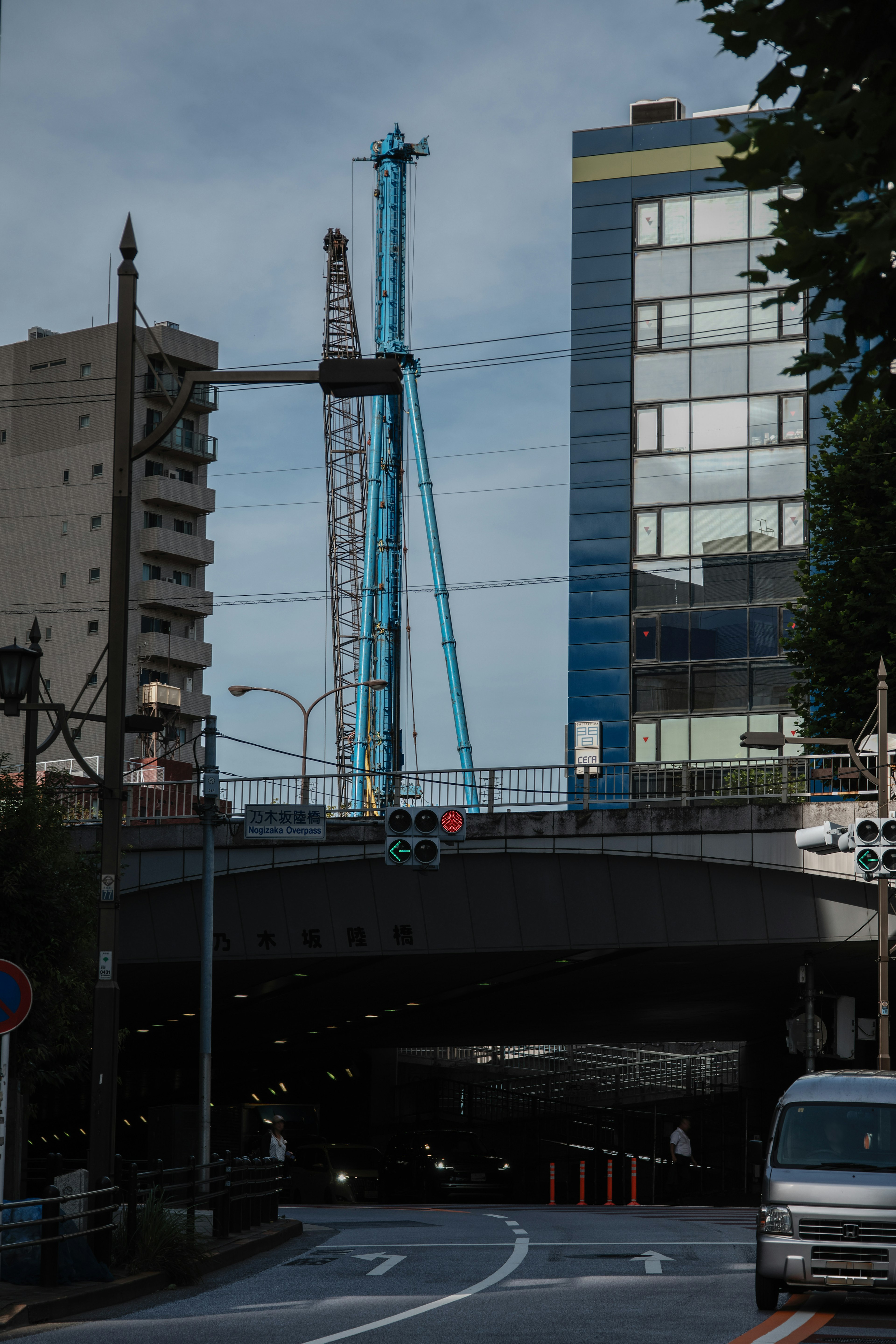 Städtische Szene unter einer Überführung mit einem blauen Kran und modernen Gebäuden