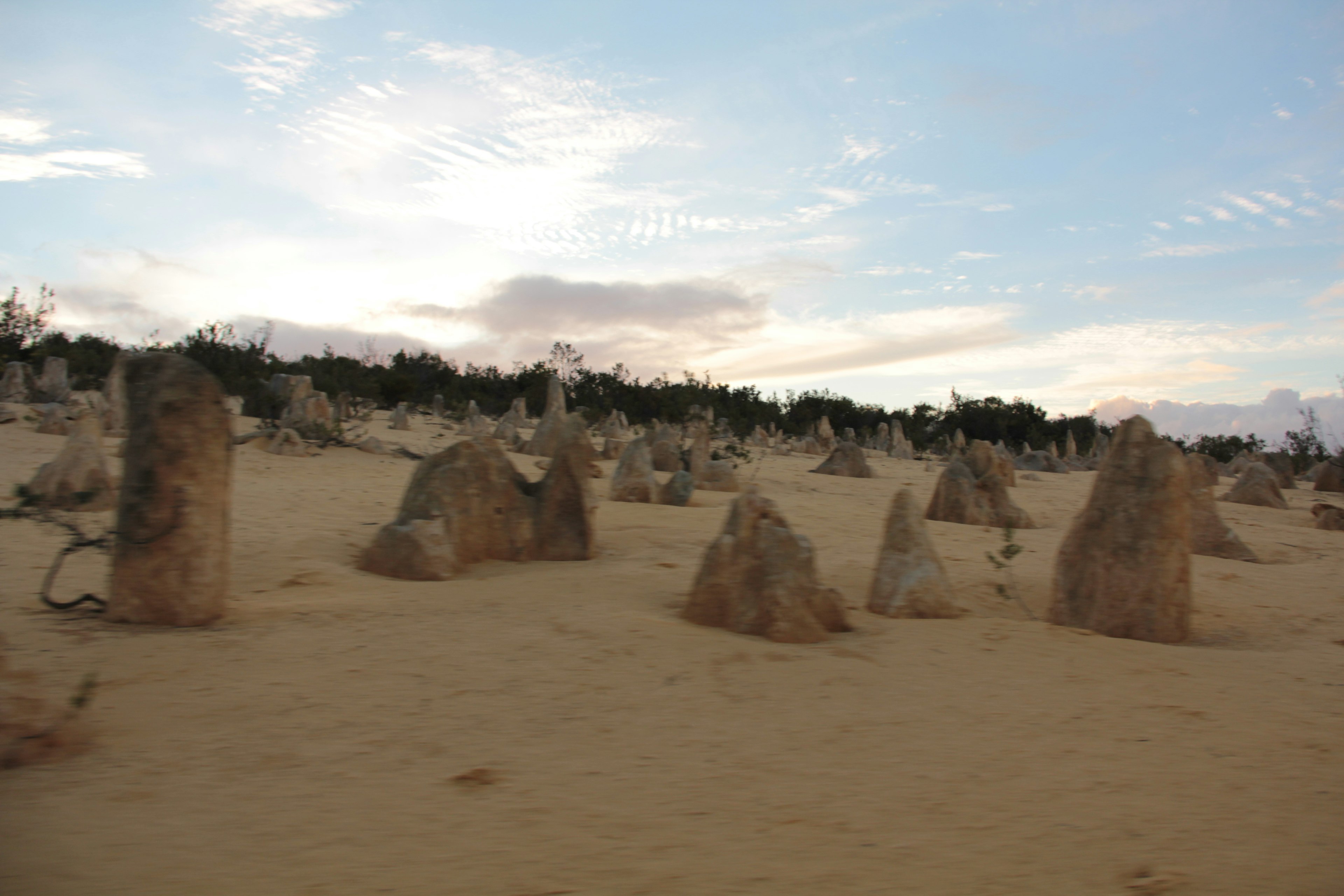 Gruppe großer Steine in einer Wüstenlandschaft unter einem blauen Himmel