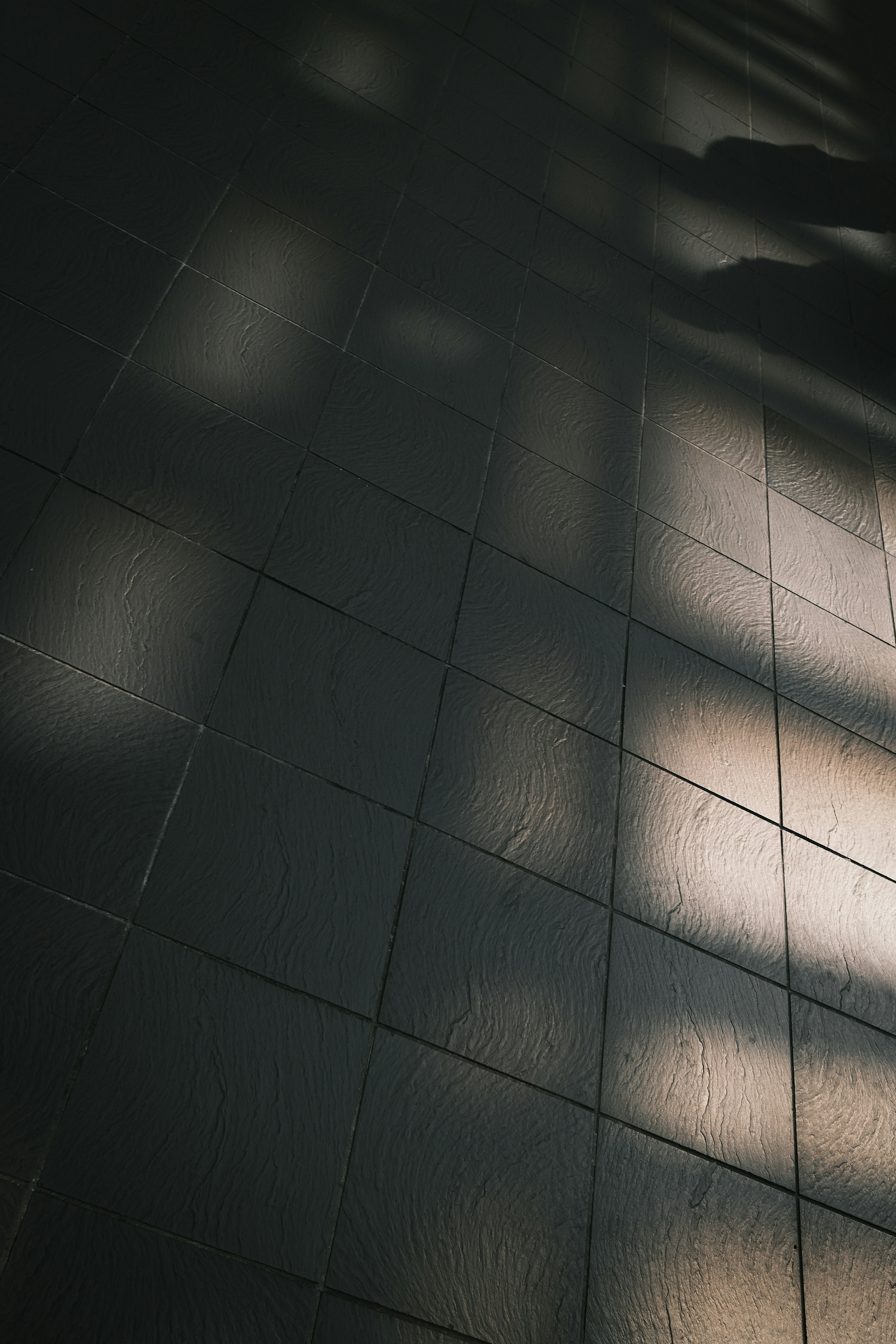 Patterns of light and shadow on a tiled floor