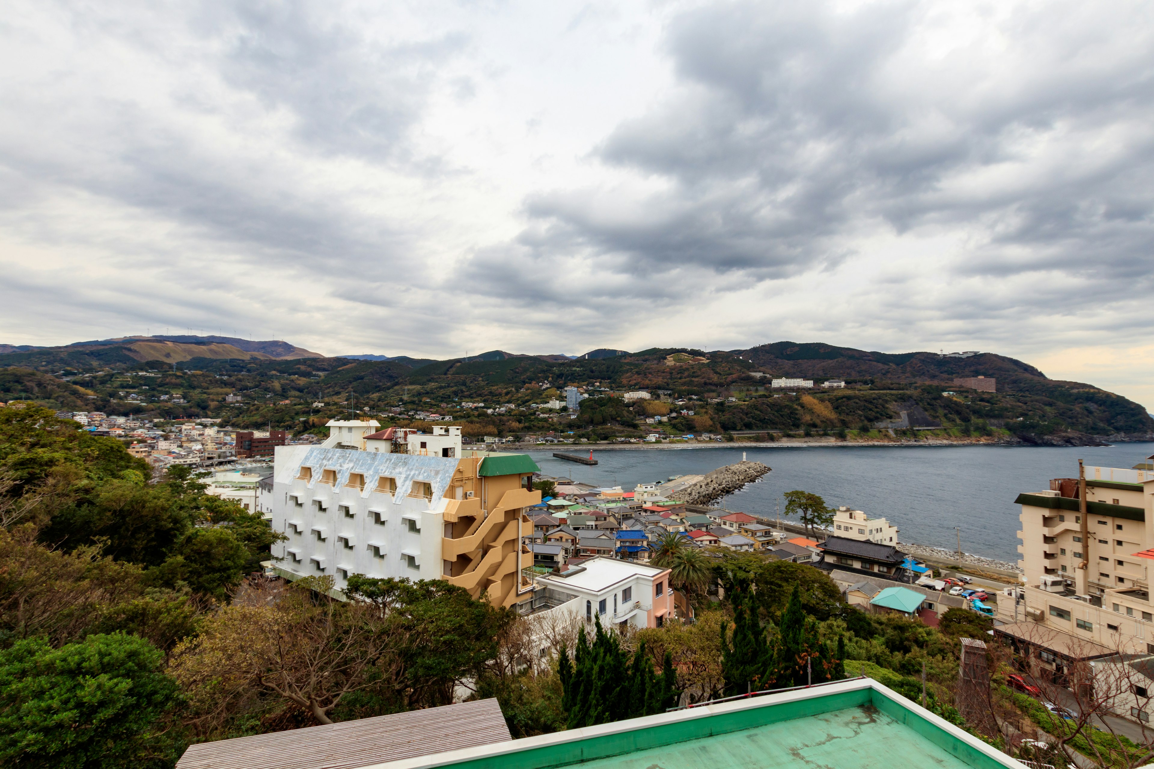 Coastal town view with cloudy sky and hillside