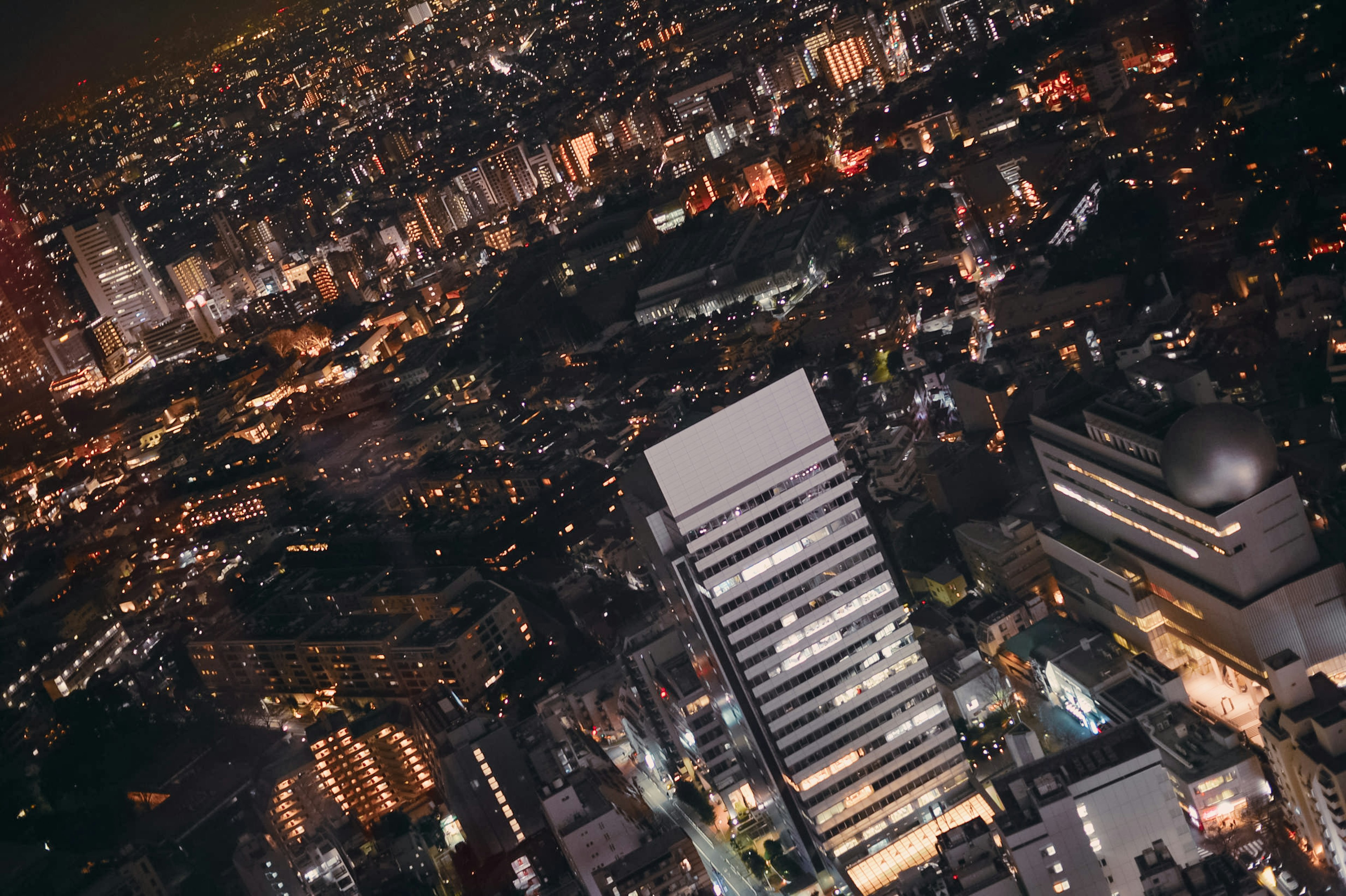 Vista aerea dello skyline di Tokyo di notte con edifici illuminati e luci della città