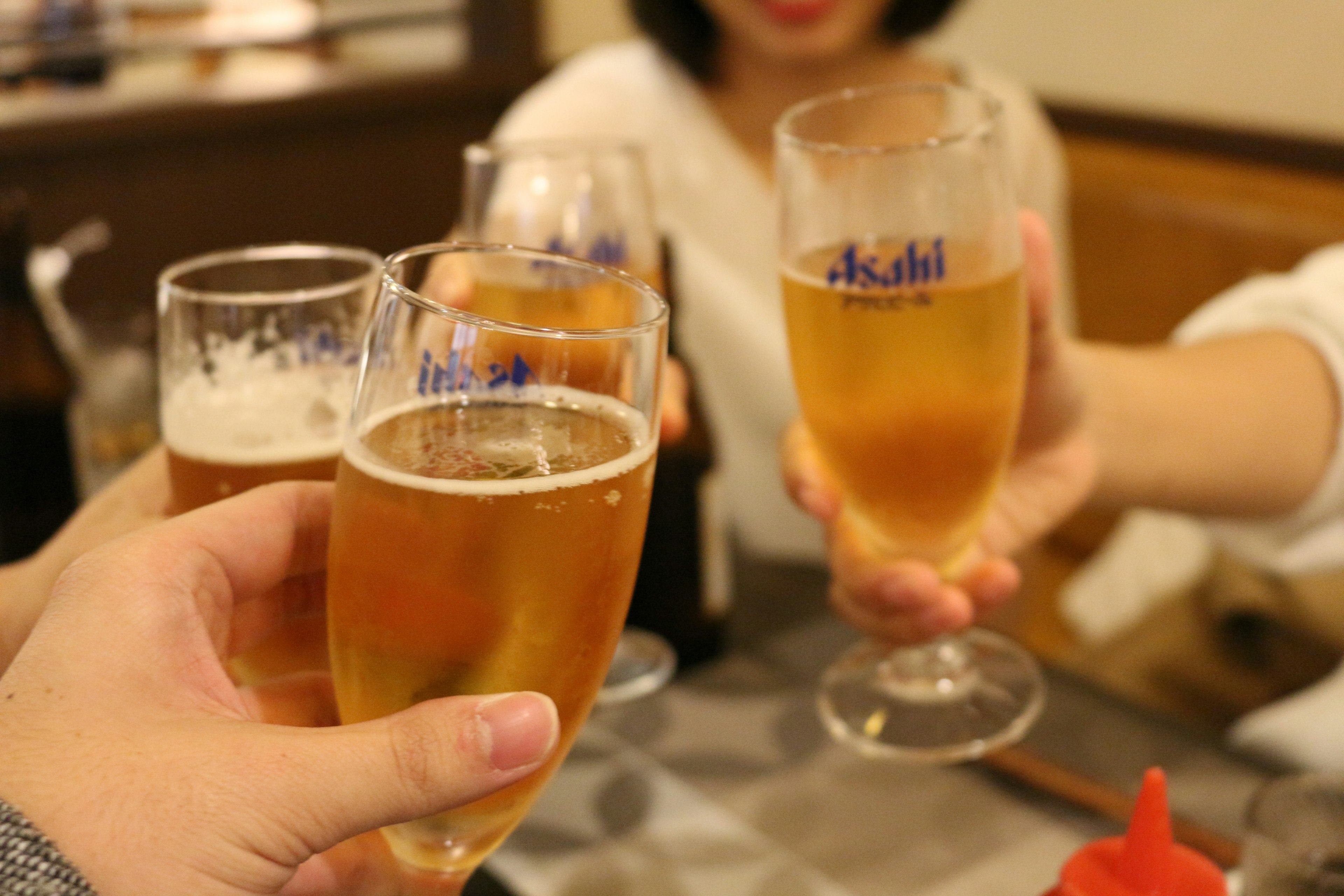 乾杯のためにビールグラスを持つ人々の手