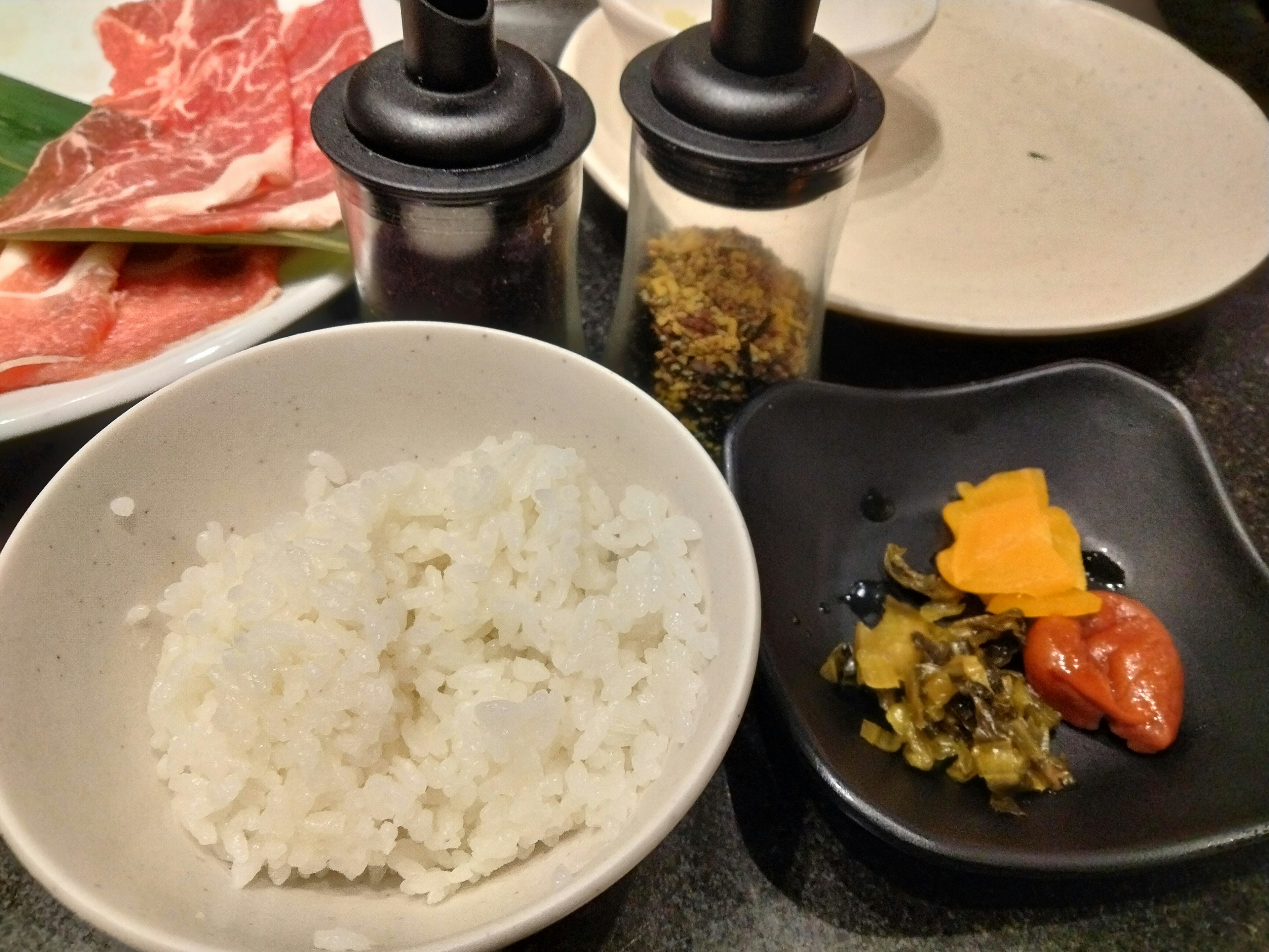 Bol de riz blanc avec des cornichons assortis sur une petite assiette