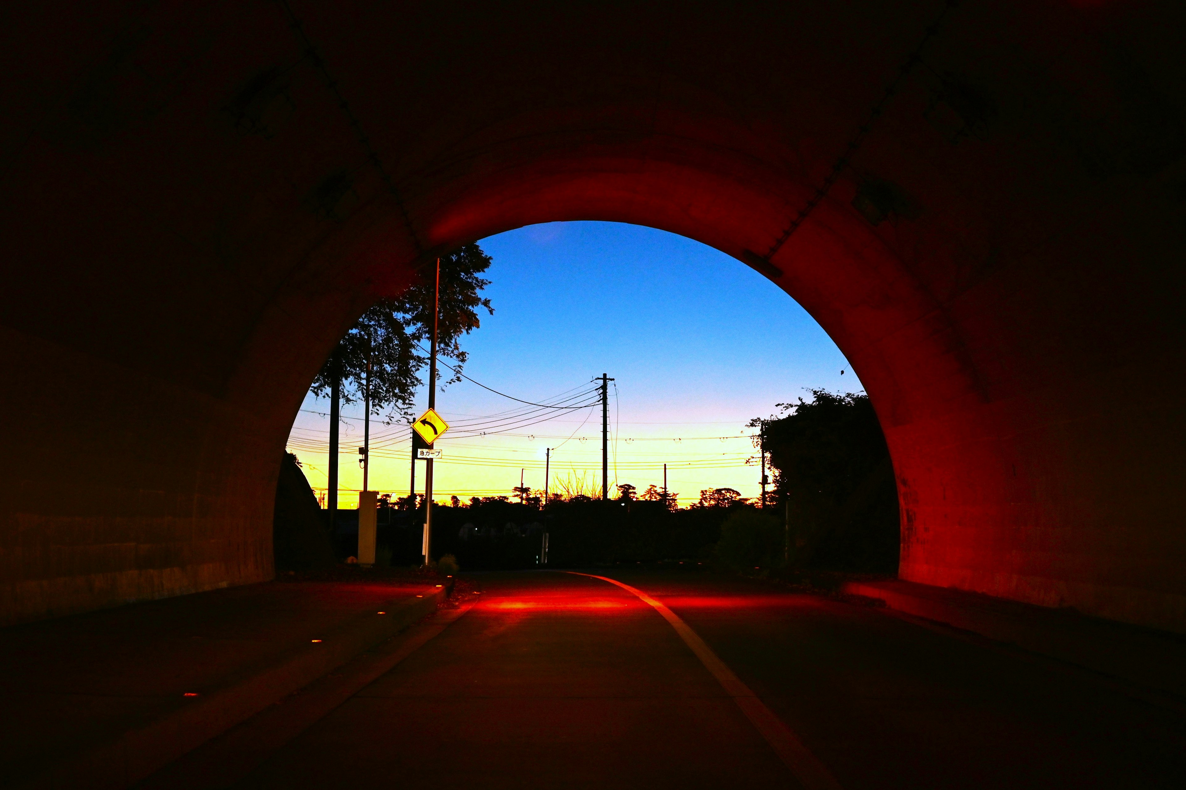 Blick auf den Sonnenuntergangshimmel und die Stadtsilhouette aus dem Tunnel