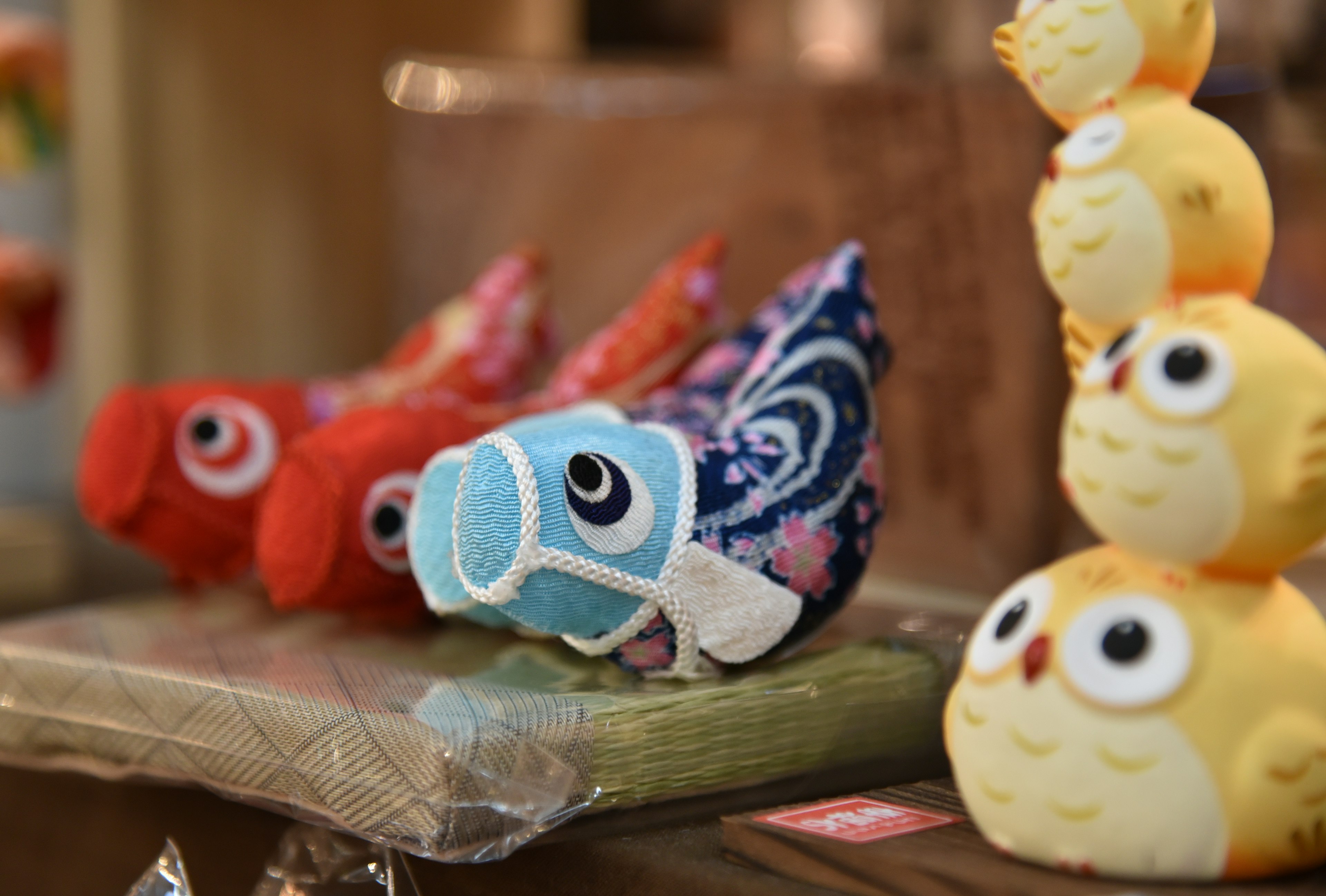 Colorful fabric fish and yellow owl figurines displayed together