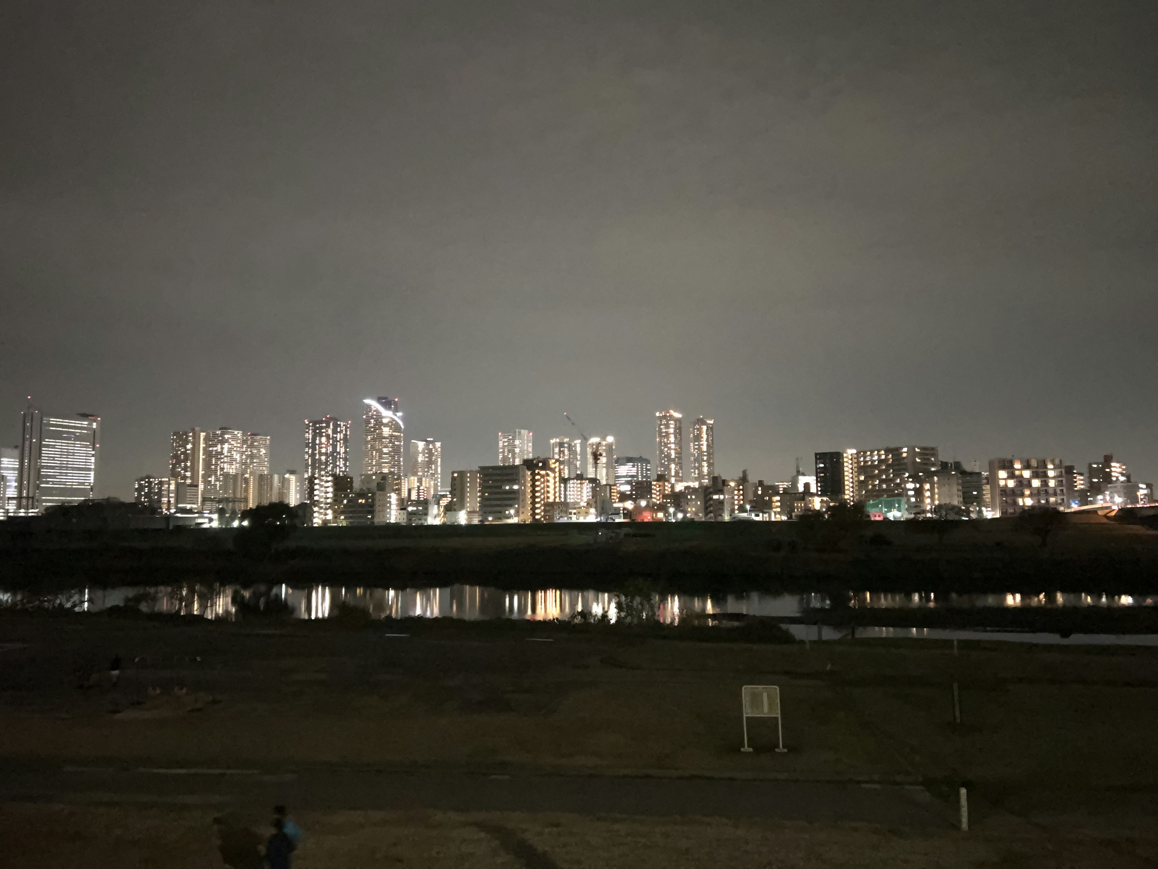 夜の都市のスカイラインと川の反射が見える風景