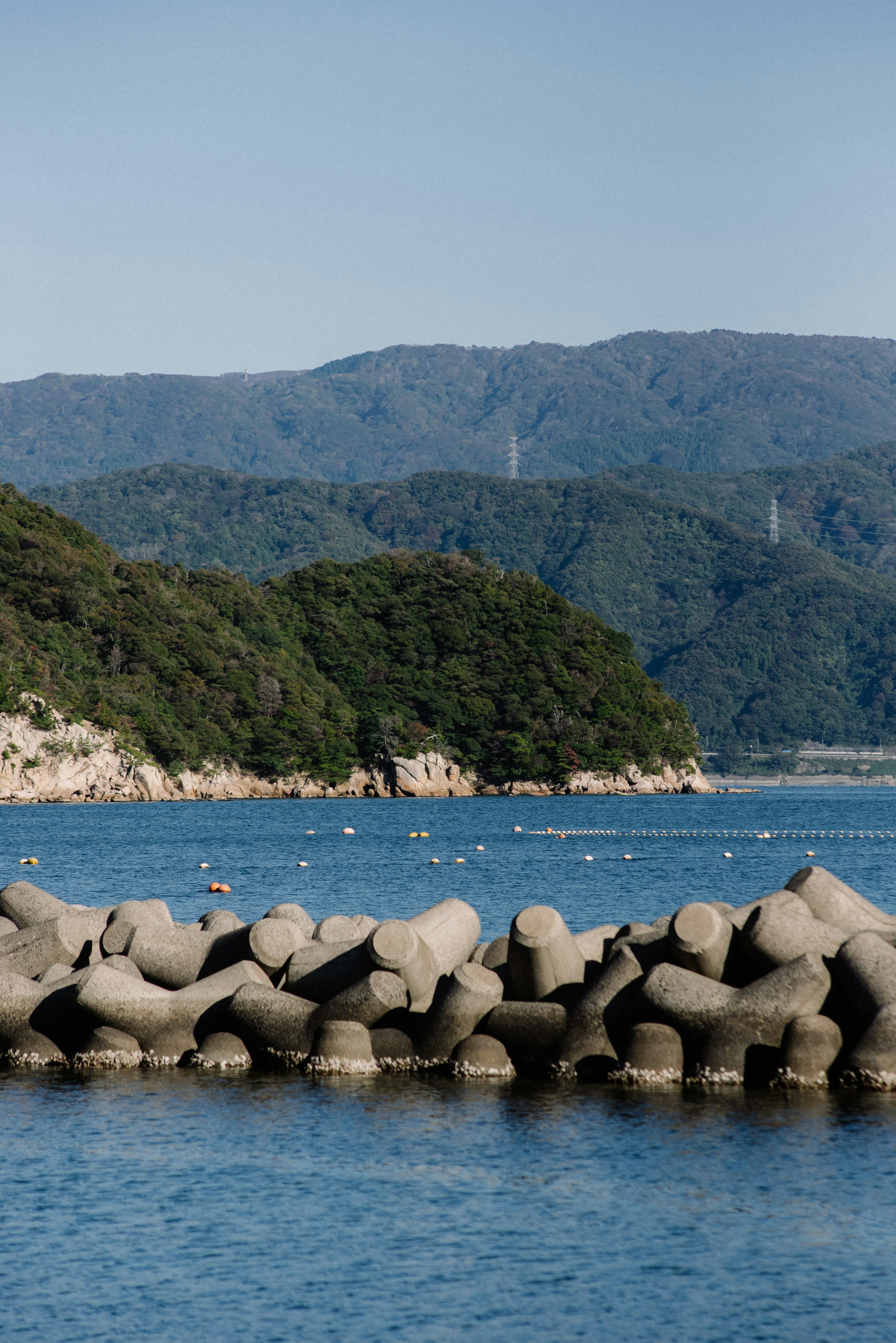 Concrete breakwater with blue sea and mountainous background