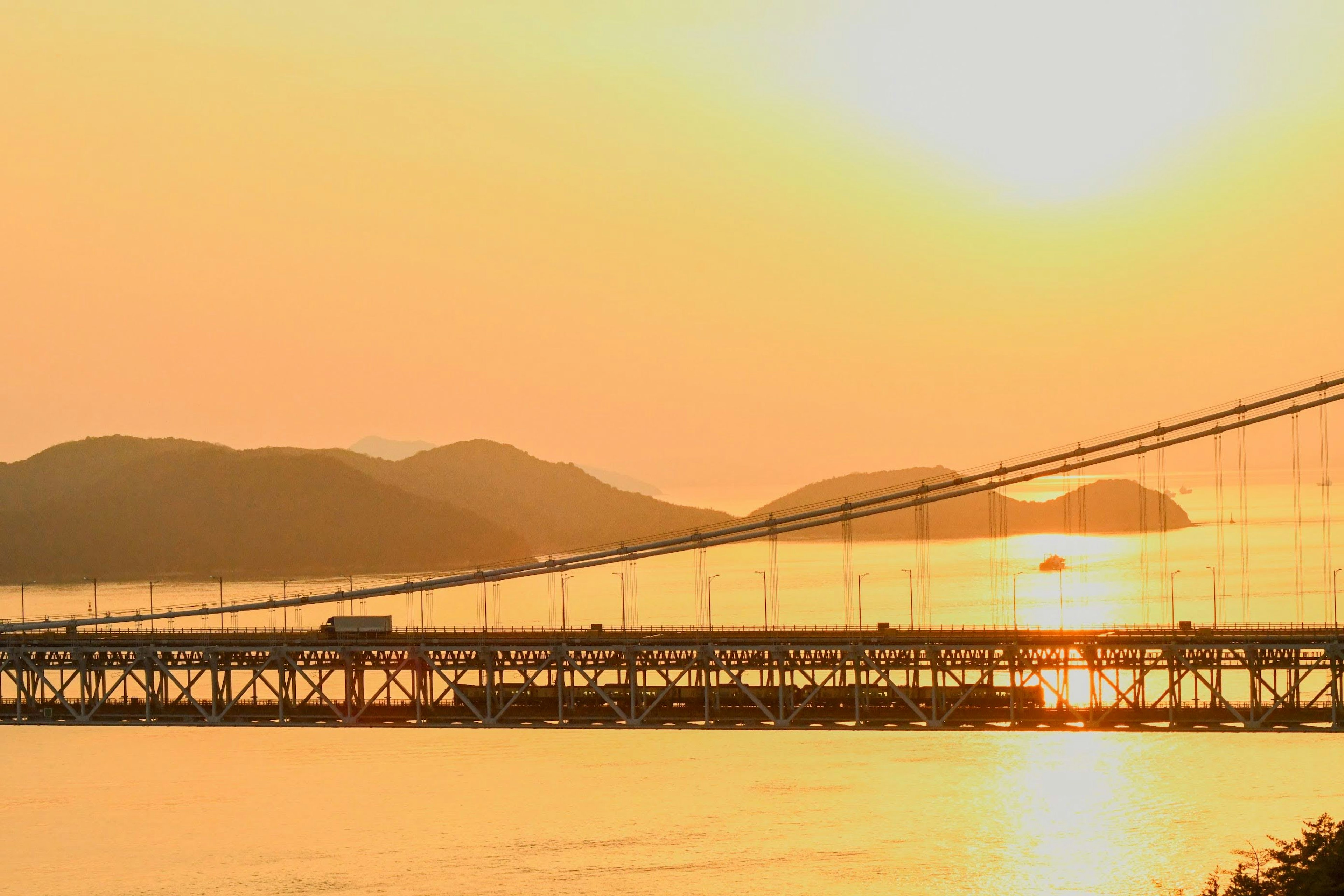 Pemandangan indah jembatan di atas laut saat matahari terbenam