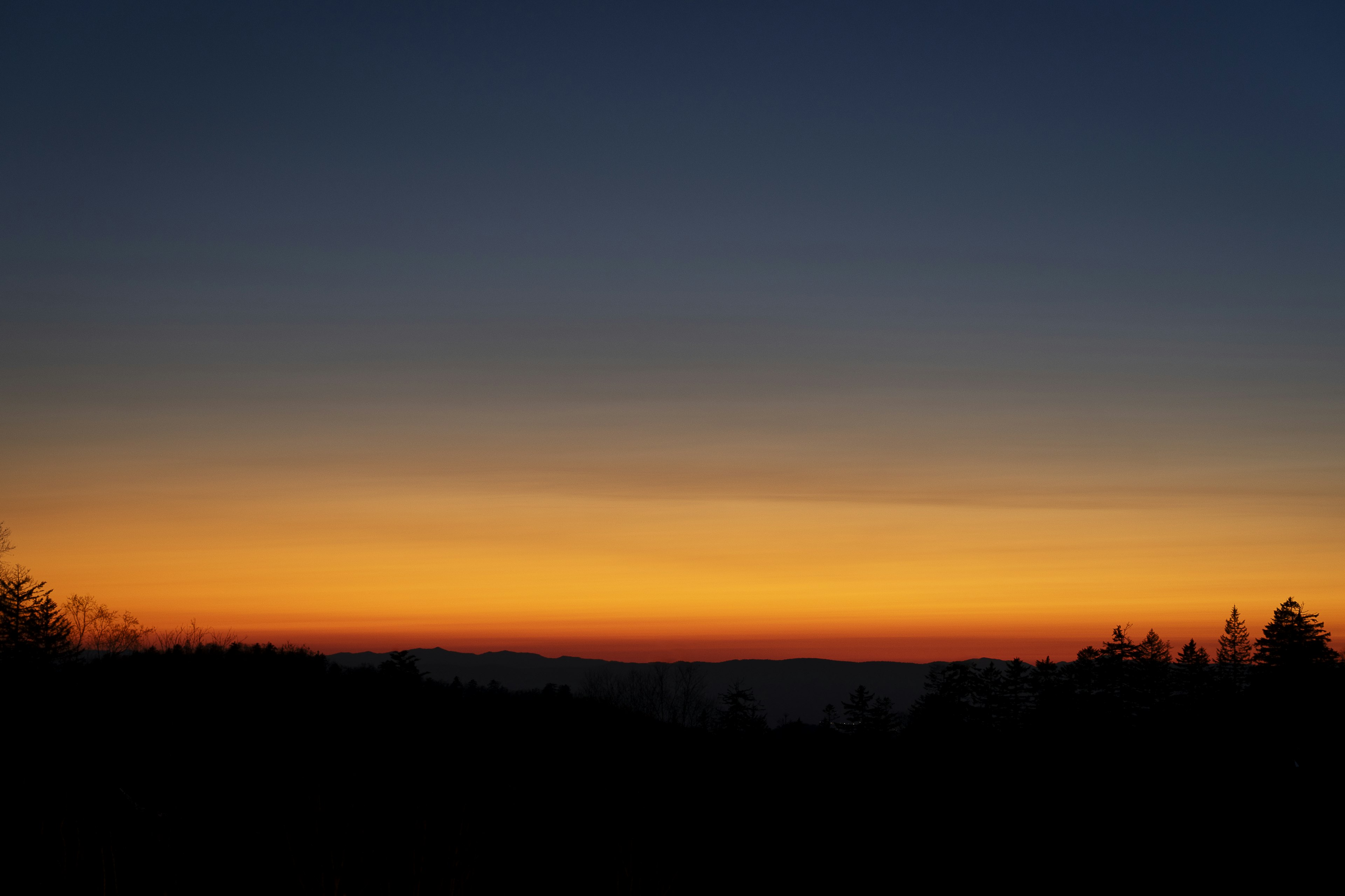 美しい夕焼けの空とシルエットの山々