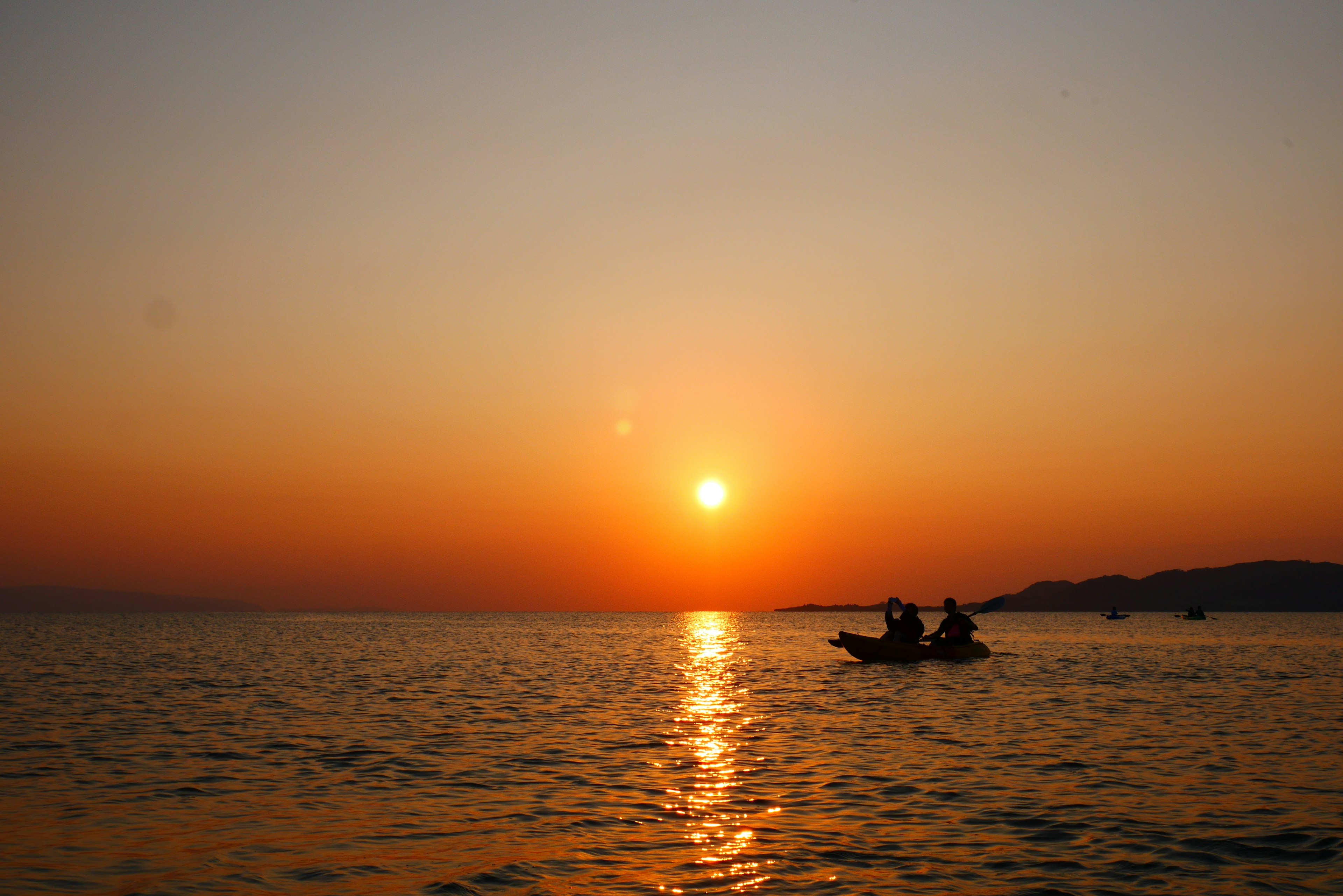 Schöner Sonnenuntergang über dem Ozean mit einem kleinen Boot