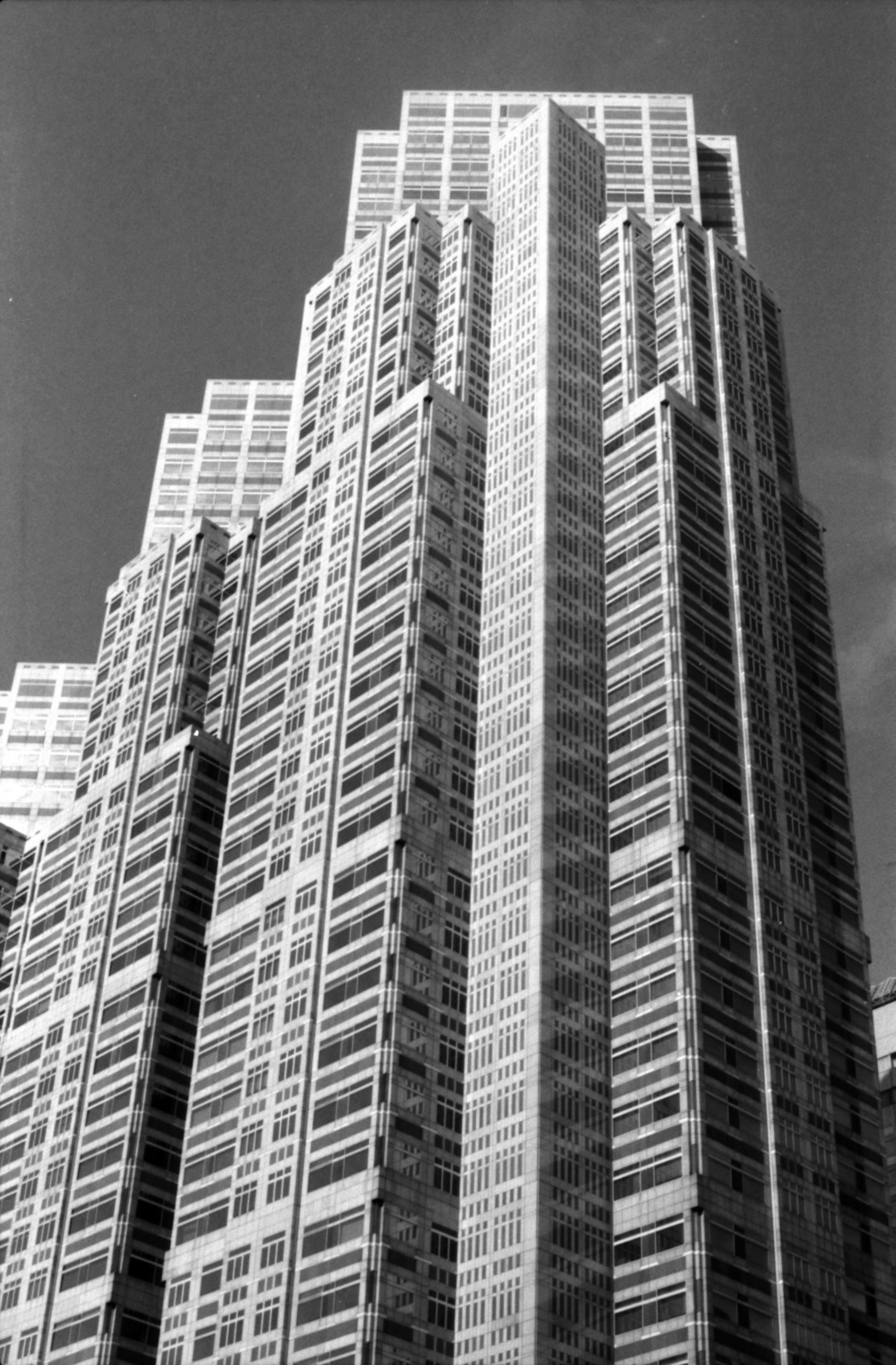 Foto en blanco y negro de un rascacielos que muestra un diseño arquitectónico único y una disposición de ventanas distintiva