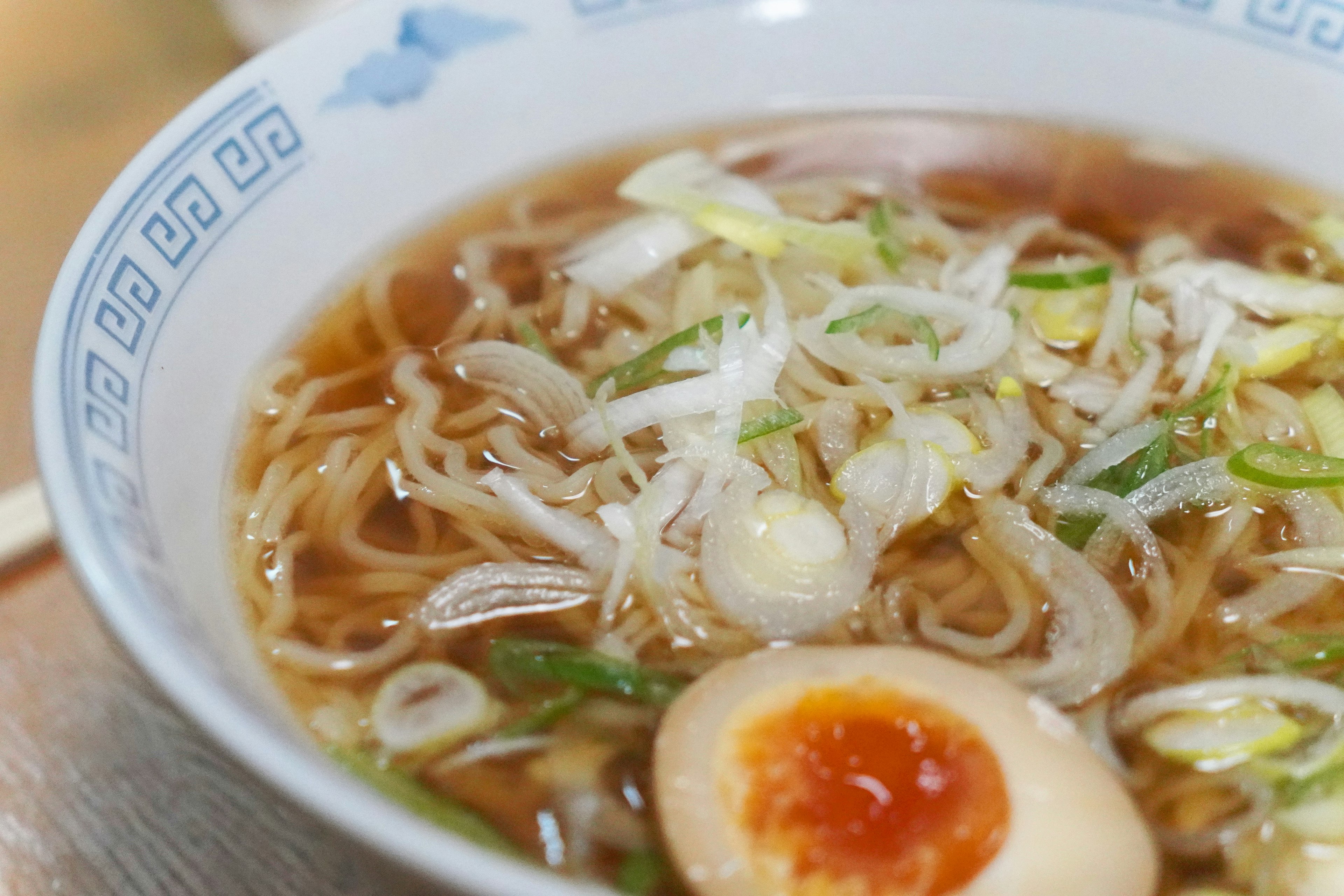 A bowl of ramen with green onions and a soft-boiled egg