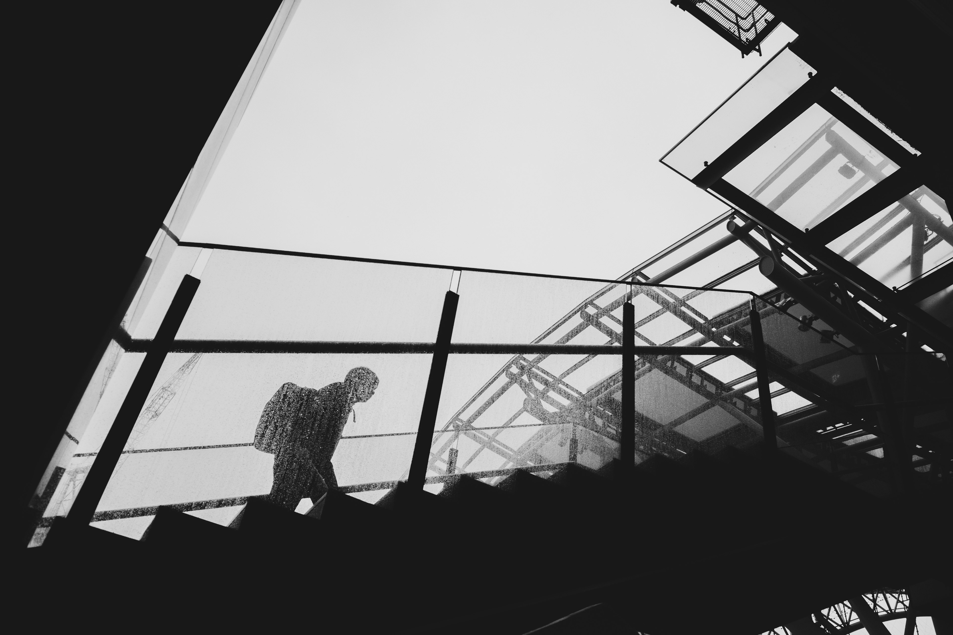 Silhouette of a person ascending stairs with modern architectural elements