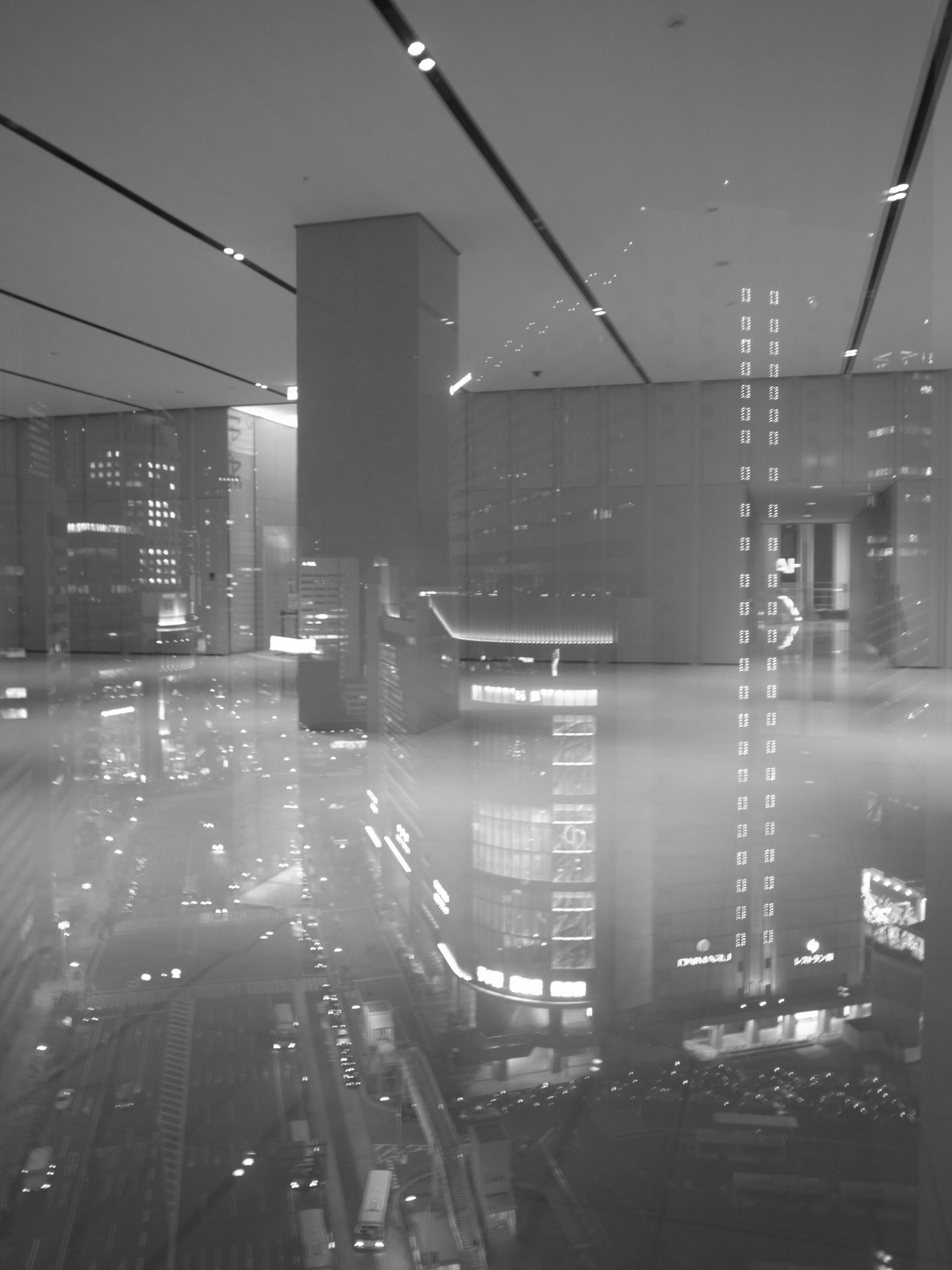 Photo en noir et blanc de gratte-ciels urbains avec des reflets et du brouillard