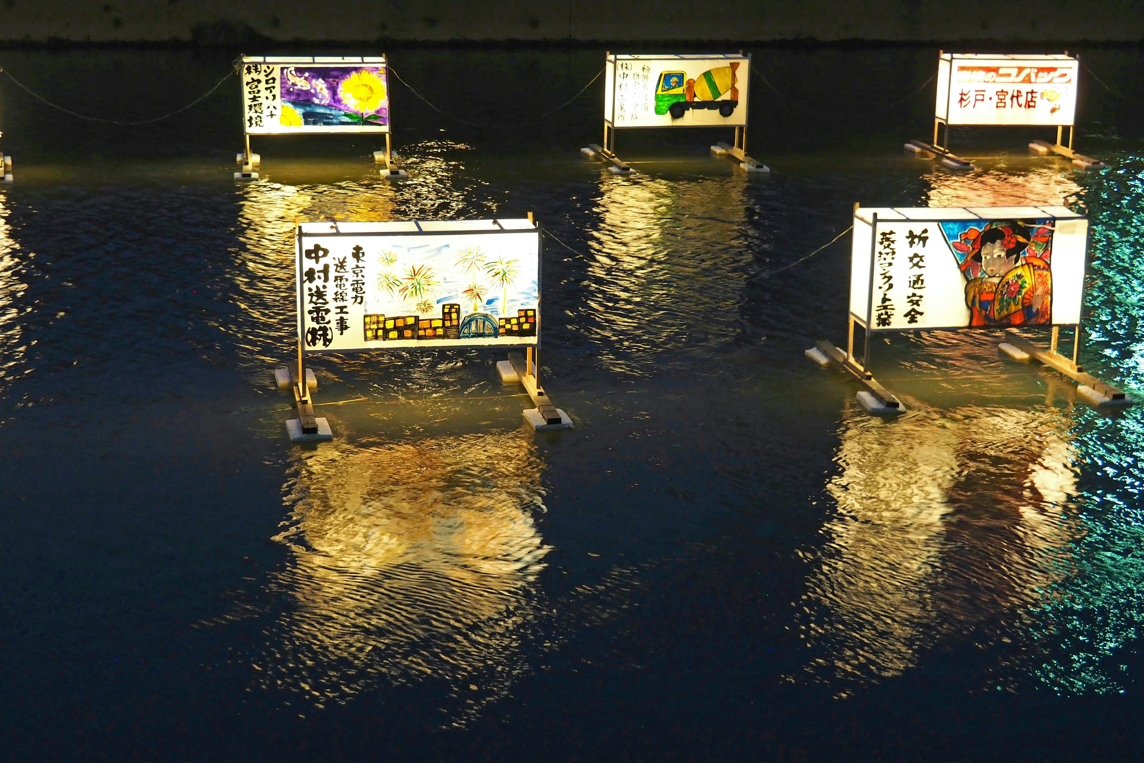 Escena nocturna con letreros iluminados flotando en el agua y sus reflejos