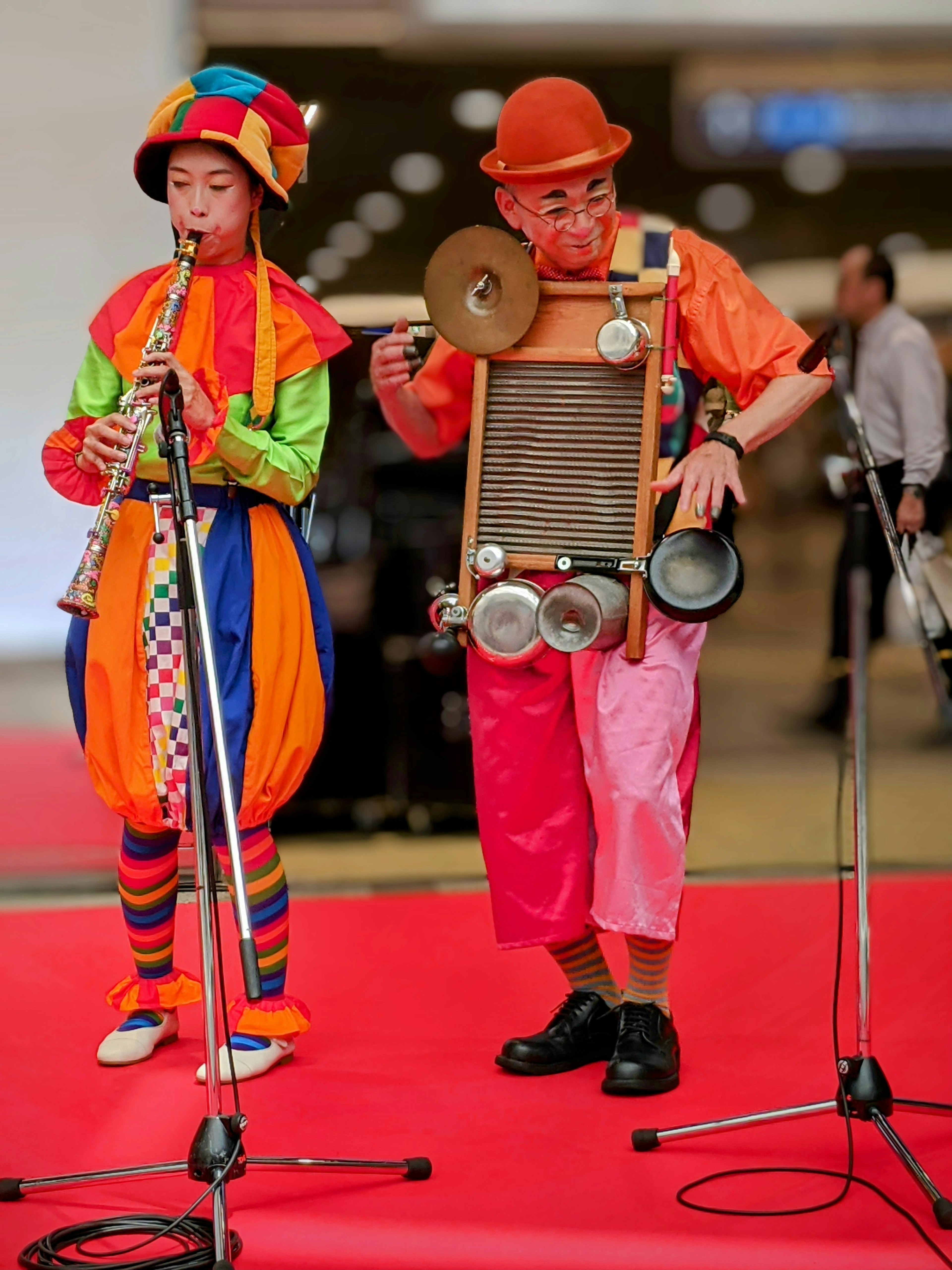 两位穿着五彩斑斓服装的小丑正在表演音乐