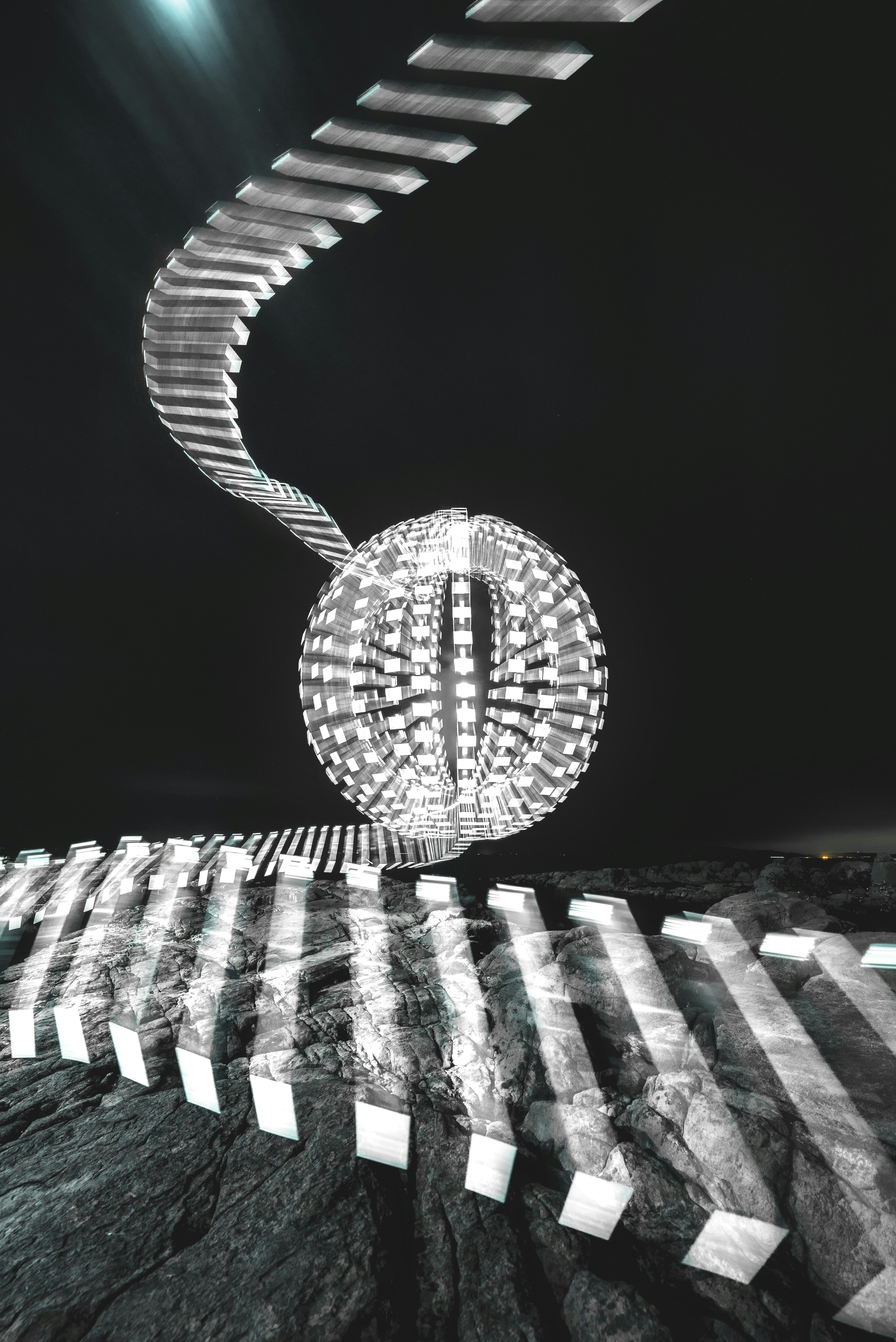 Black and white art piece featuring a spherical light and wavy shapes