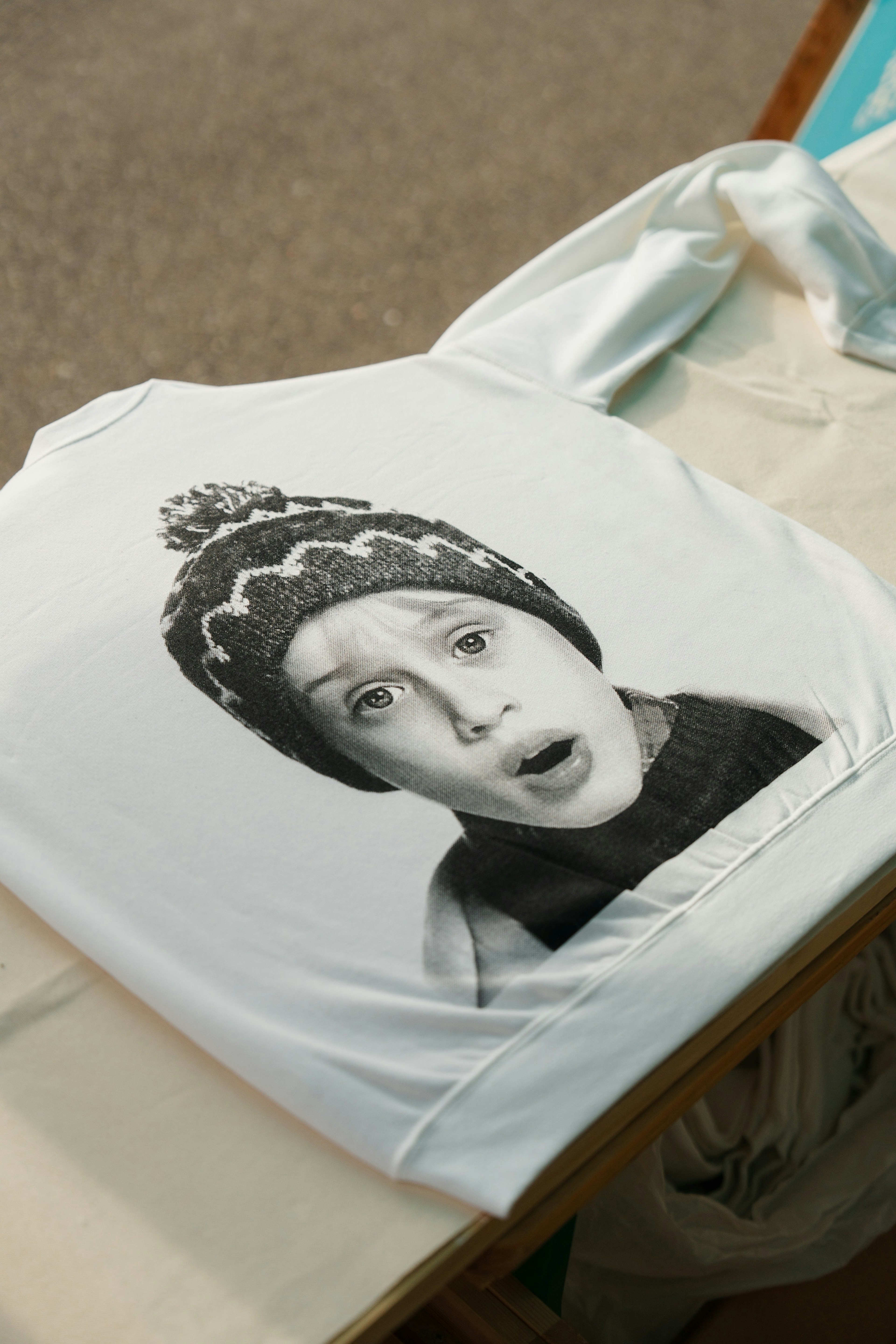 White T-shirt featuring a shocked expression of a child in black and white print