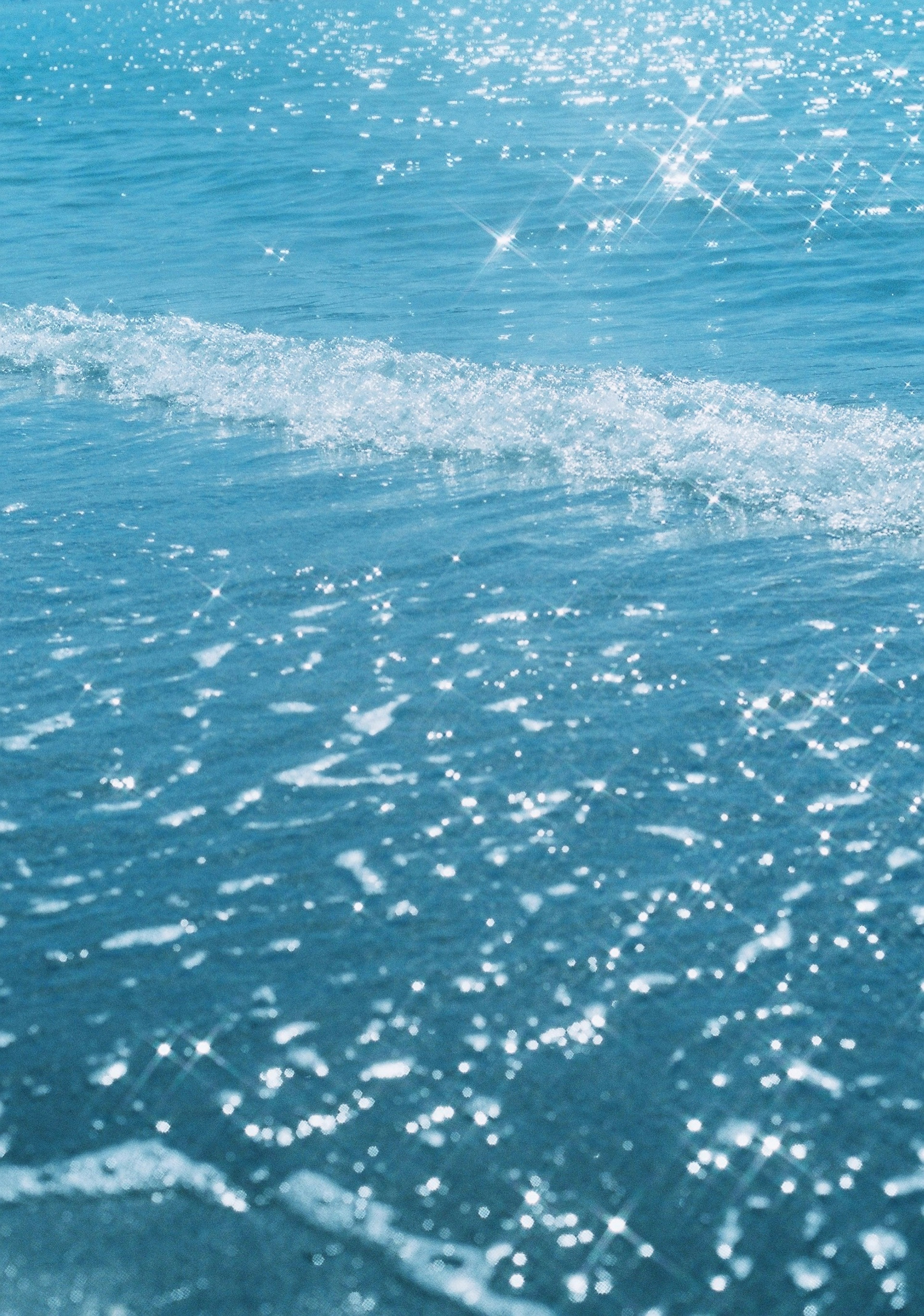 青い海の水面に反射する光と波の詳細