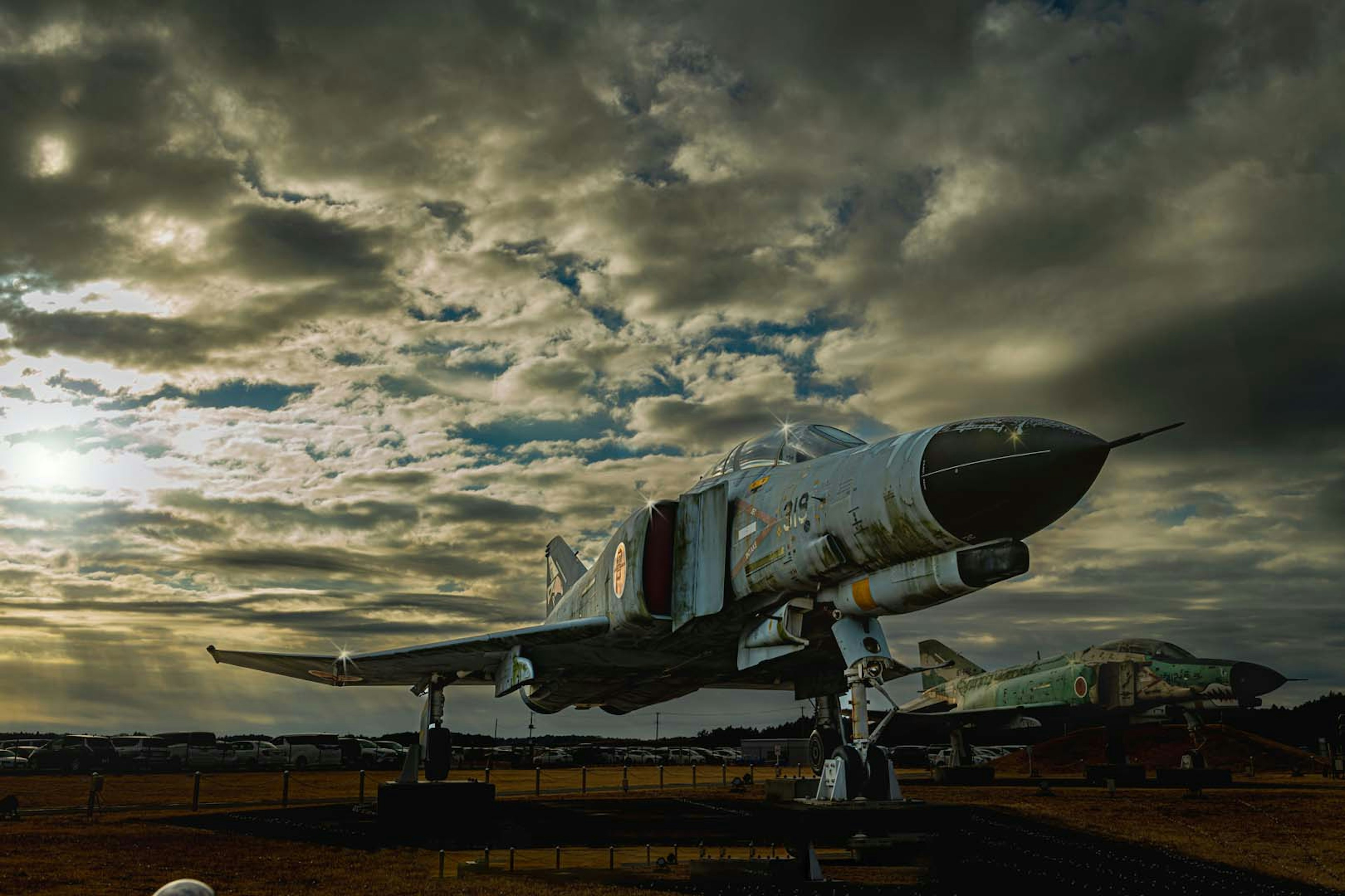 Un modello di aereo esposto sotto un cielo drammatico al tramonto