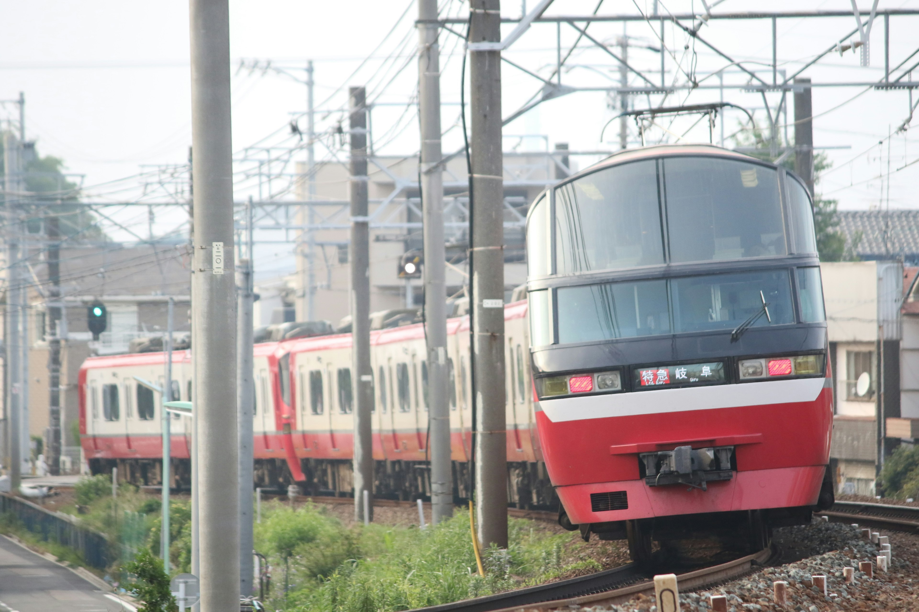 赤と白の電車が線路を走行している風景