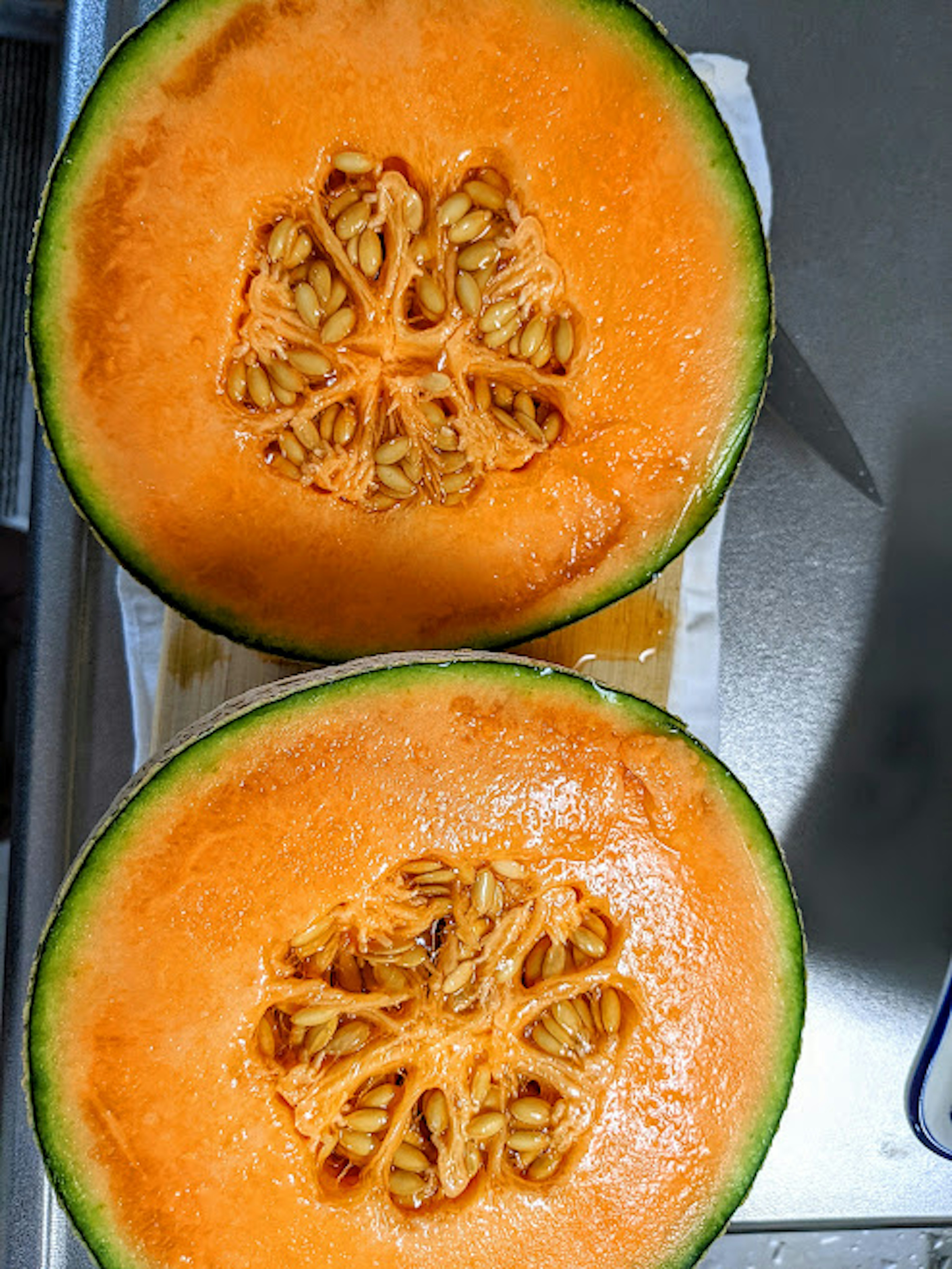 Cut melon viewed from above with orange flesh and visible seeds