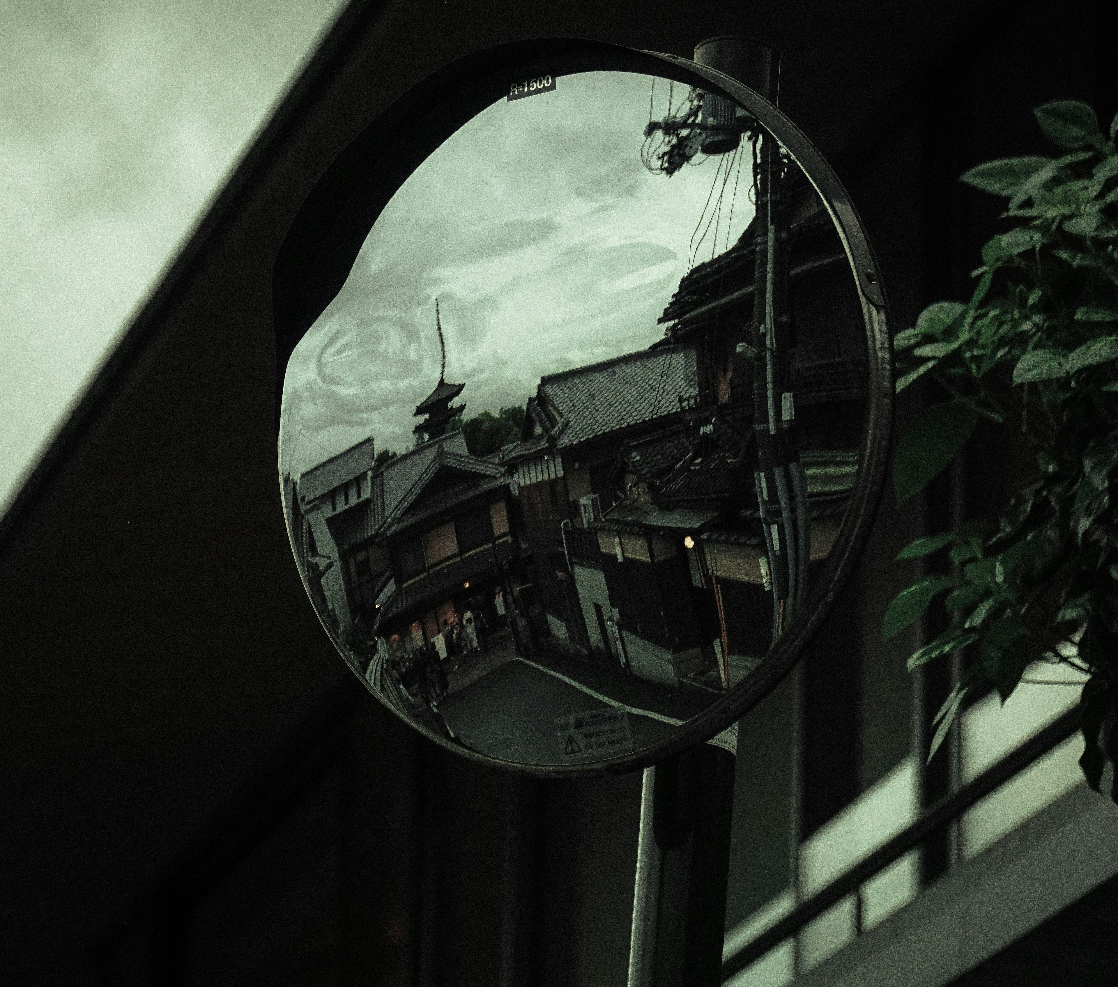 街の景色が反映されたミラーの写真 夕暮れの雰囲気と緑の色合い