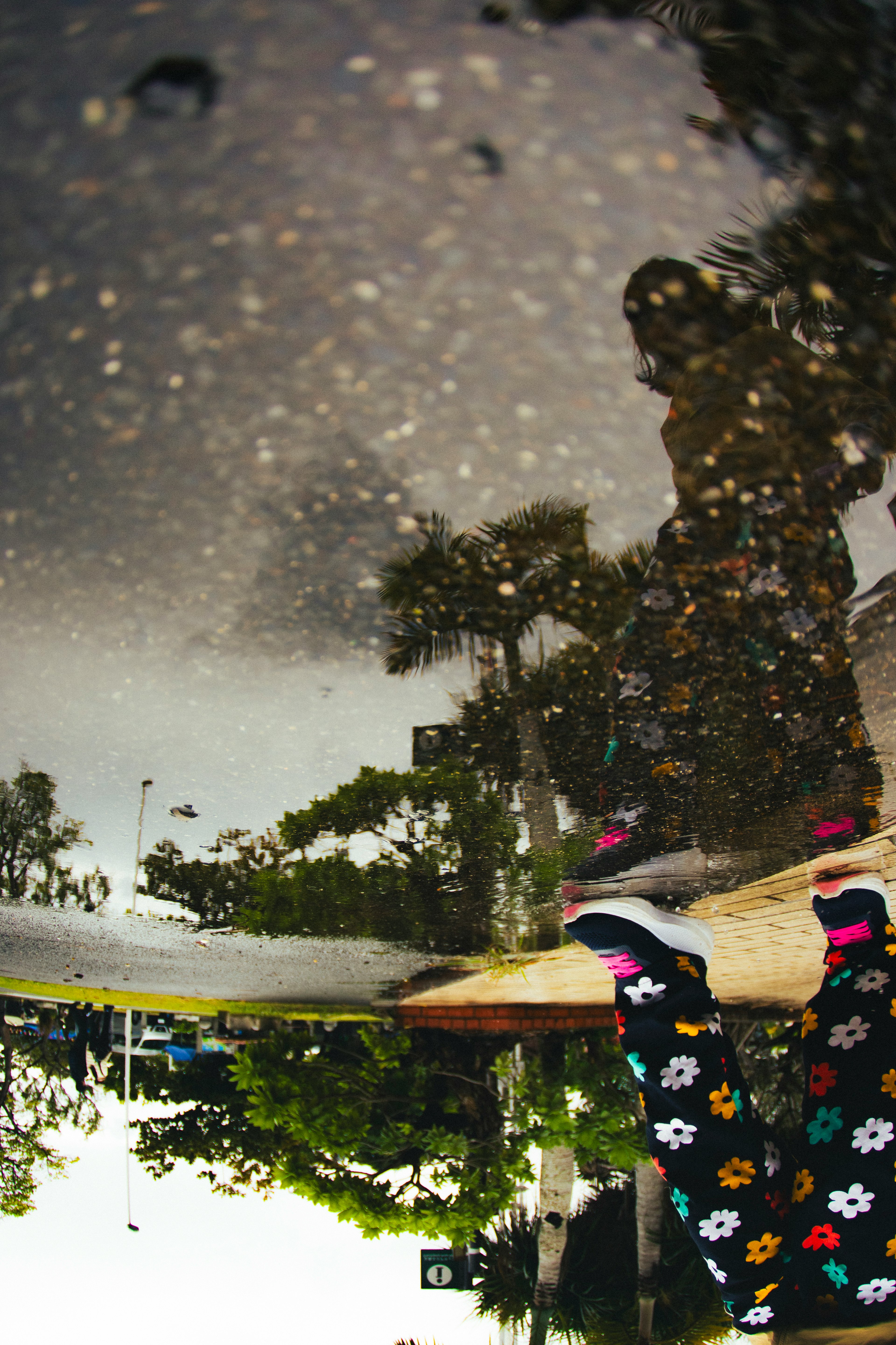 Reflection of colorful socks and scenery in a puddle