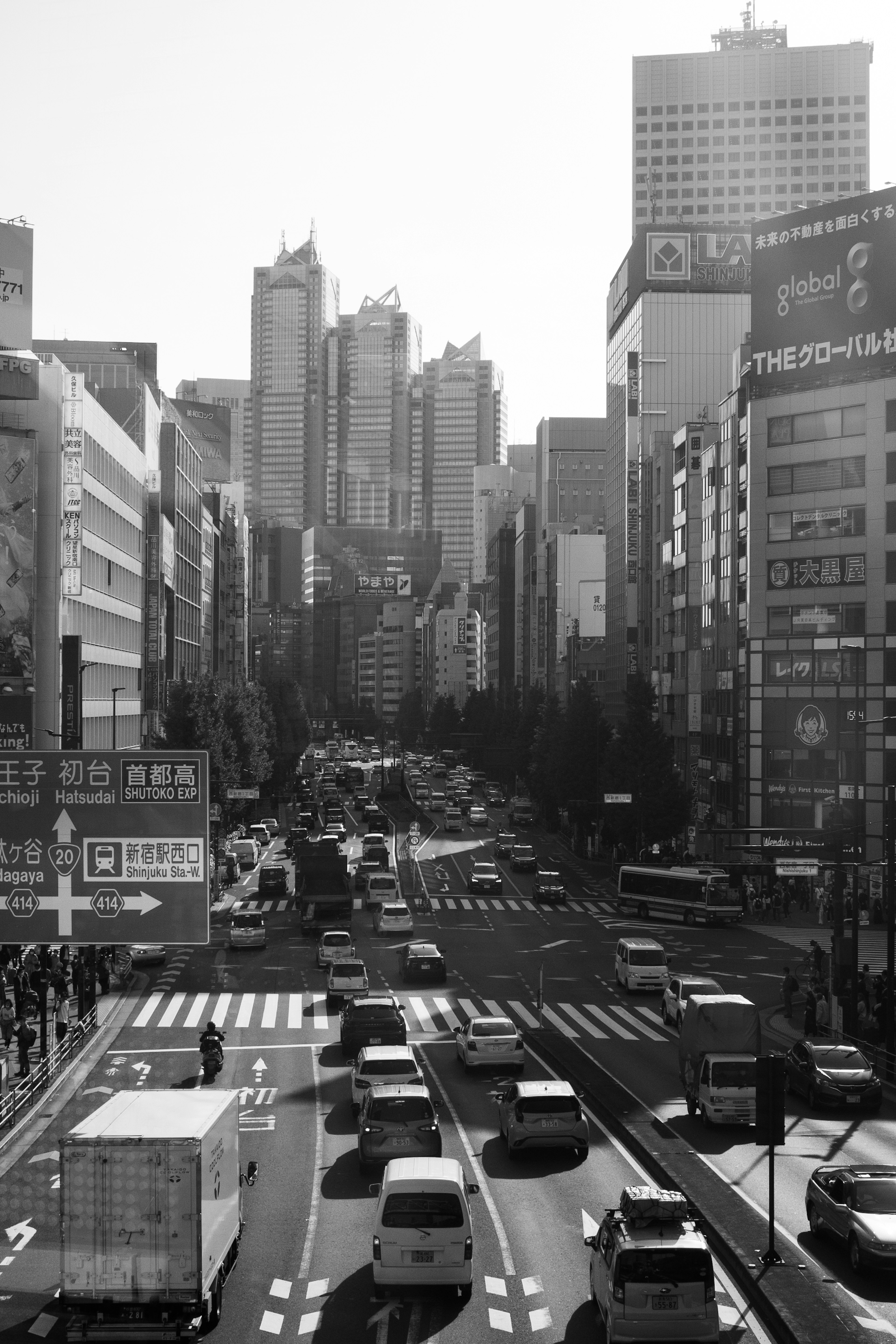 Black and white cityscape featuring skyscrapers and busy traffic