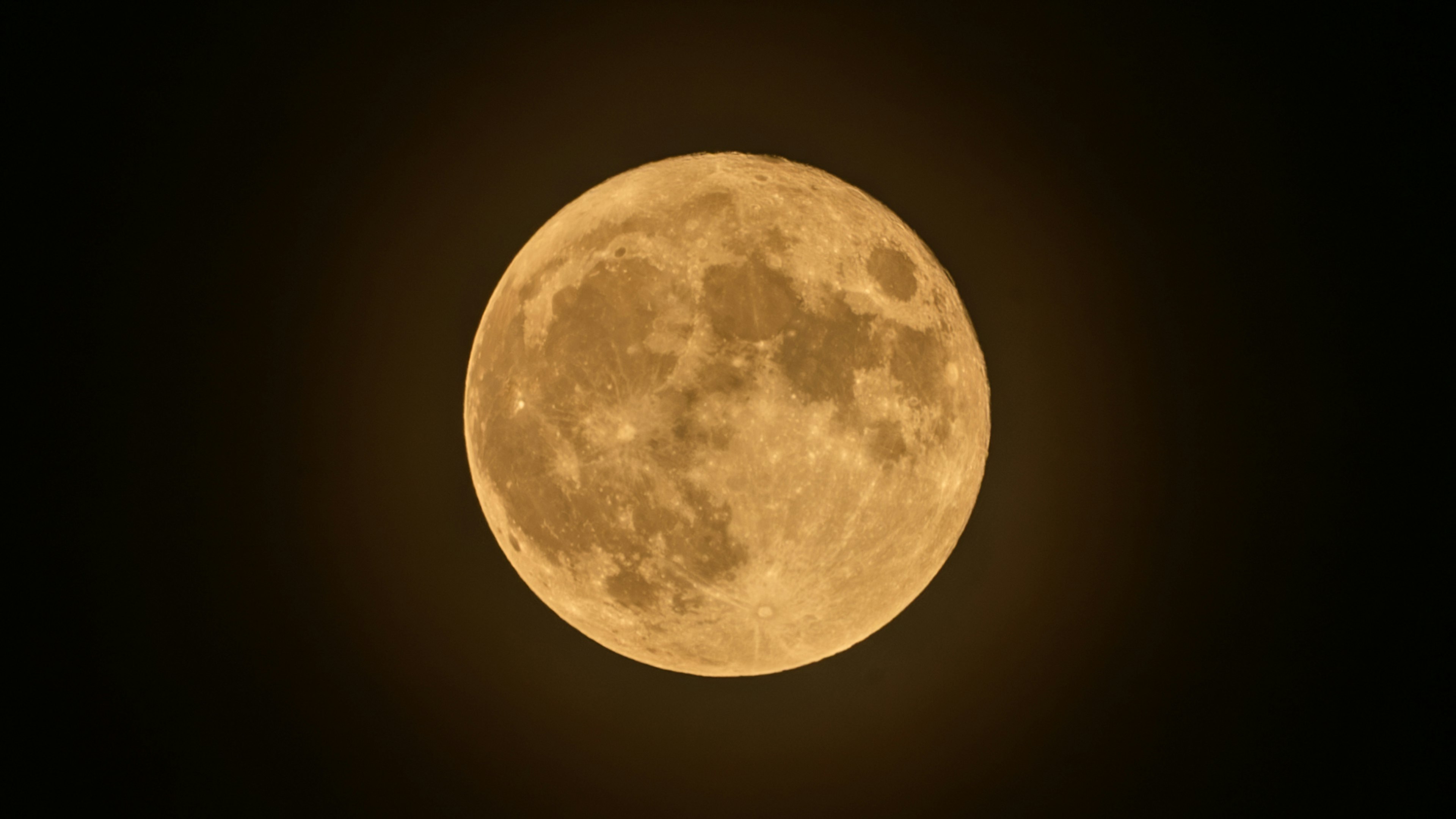 Una brillante luna llena naranja en un cielo nocturno oscuro