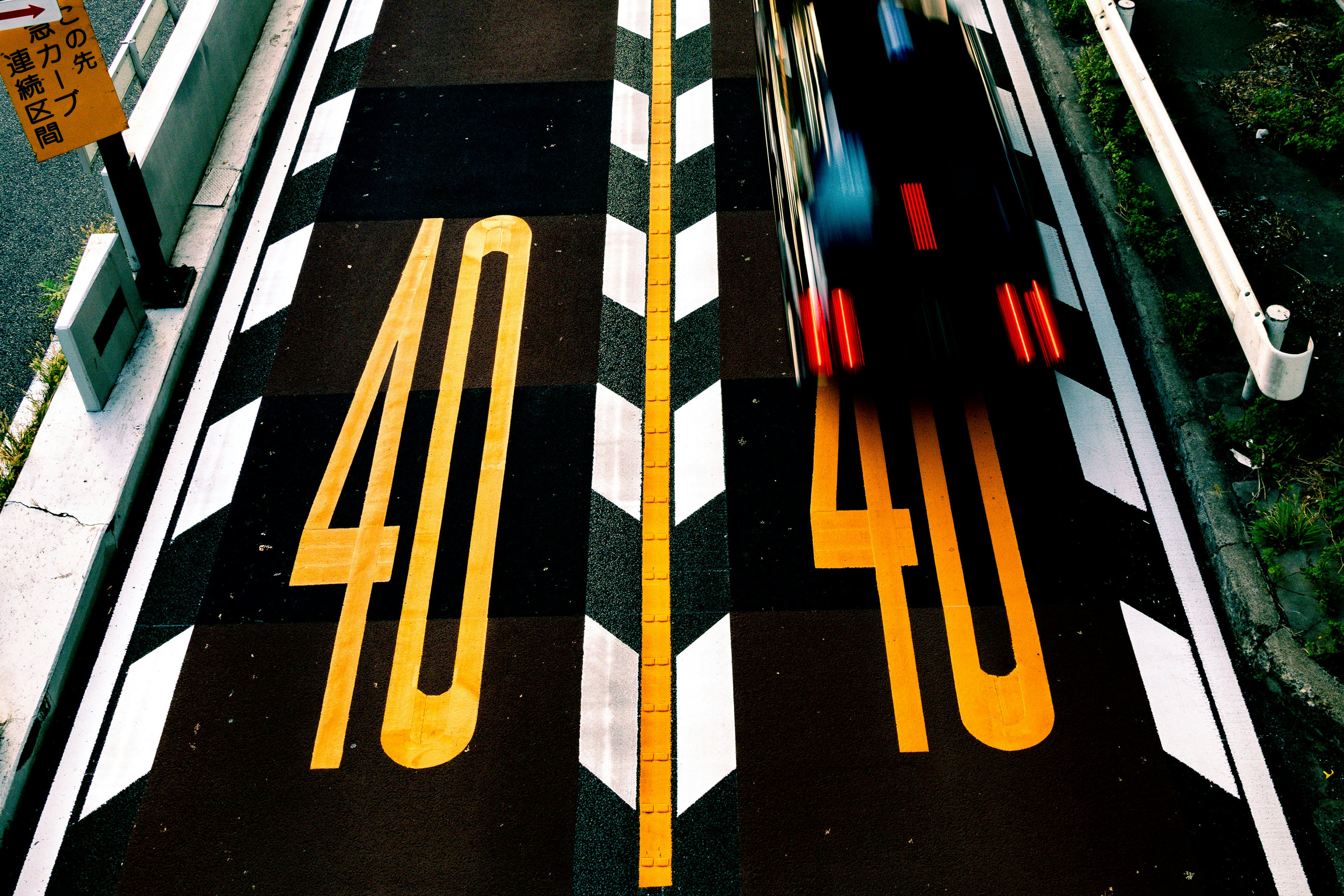 從上方查看的道路，帶有黃色40限速標記和經過的車輛