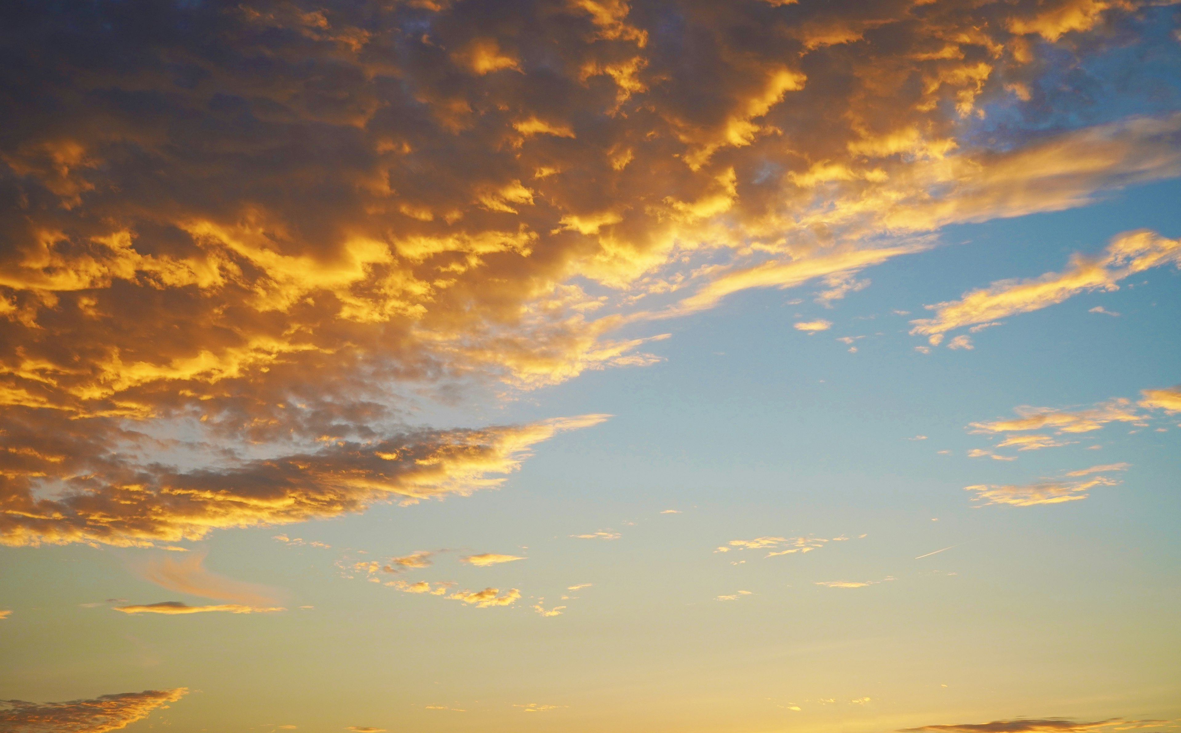 Cielo al atardecer con nubes naranjas y fondo azul