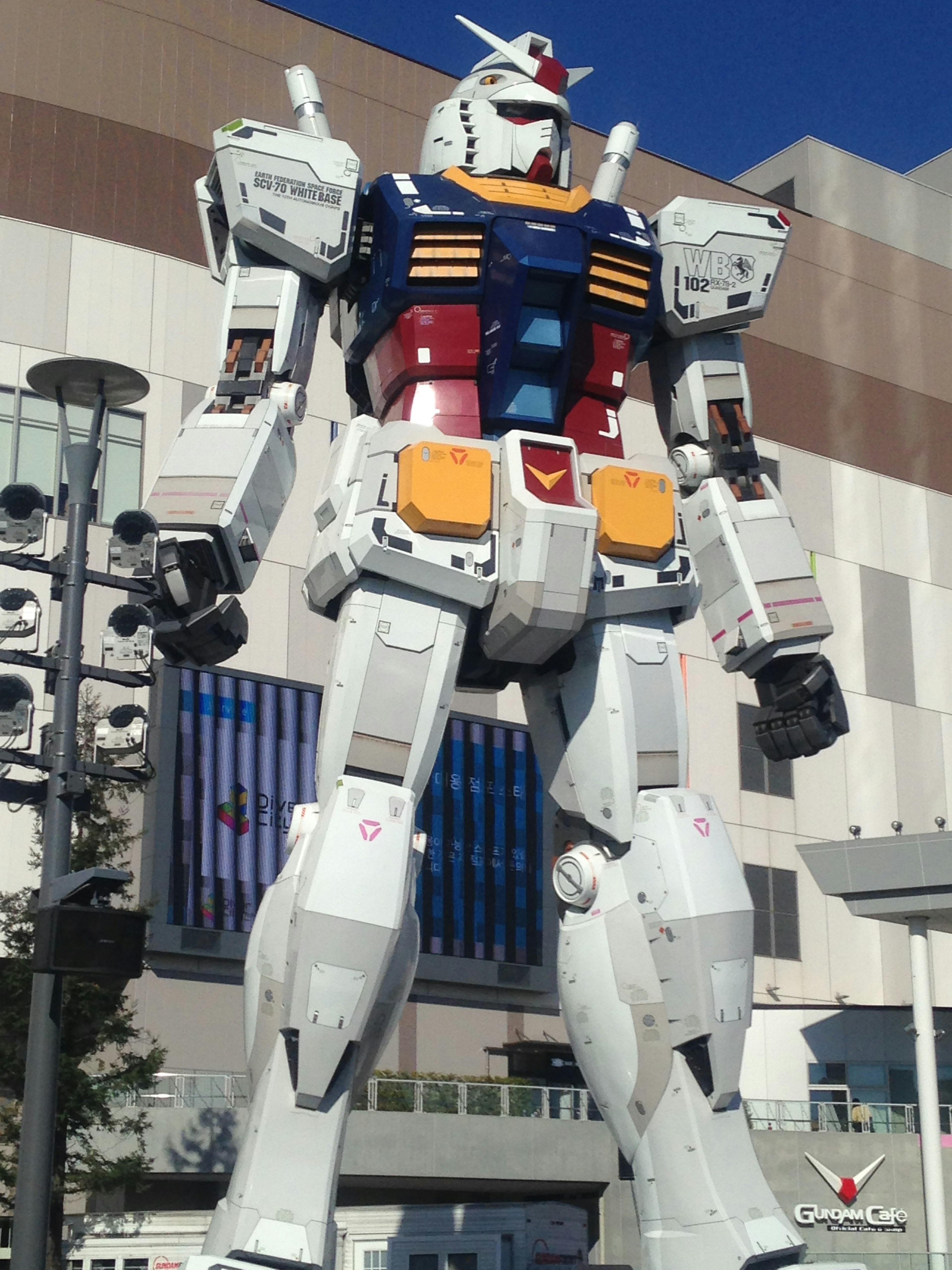 Une statue géante de Gundam se dresse sous un ciel bleu