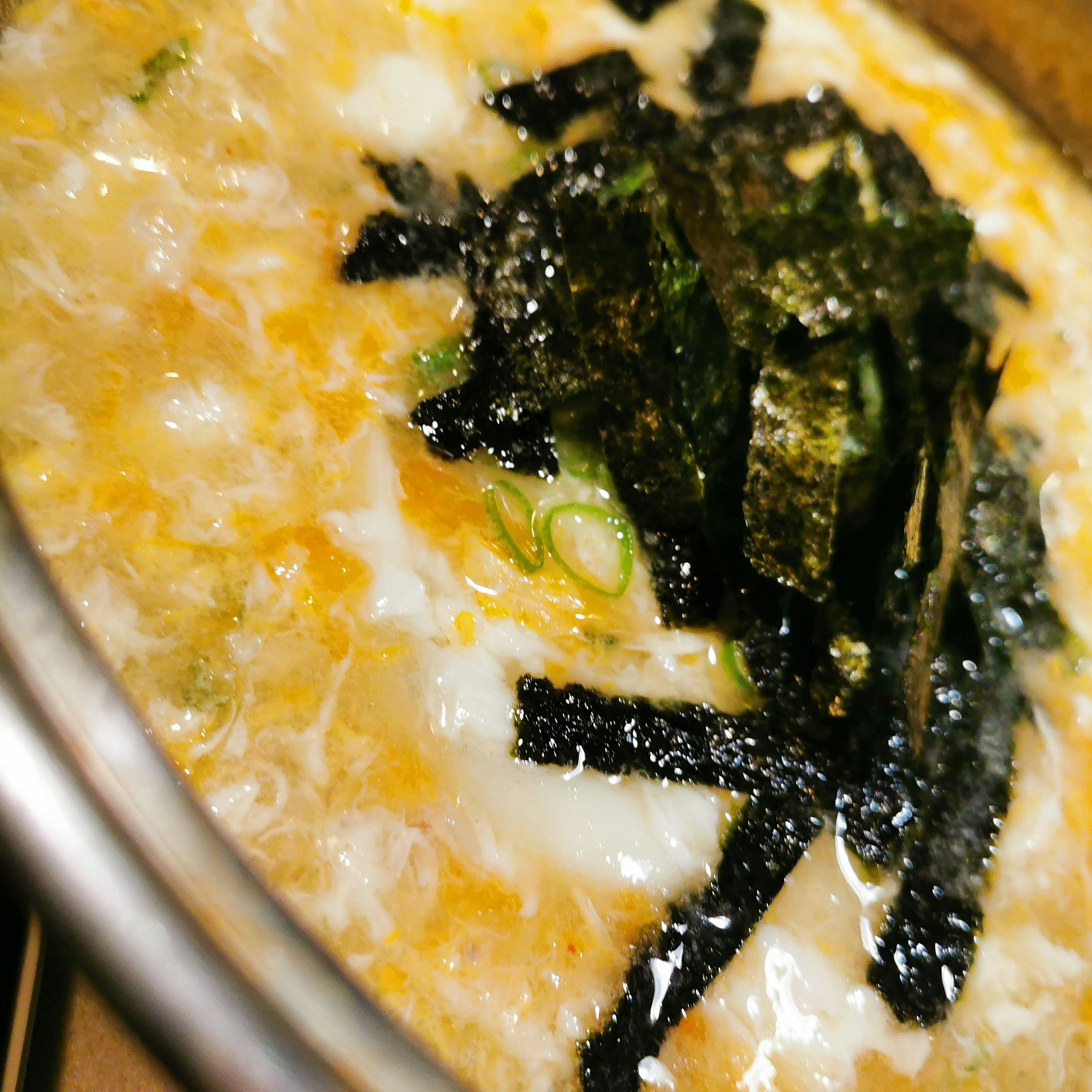 Hot egg soup topped with sliced seaweed and green onions