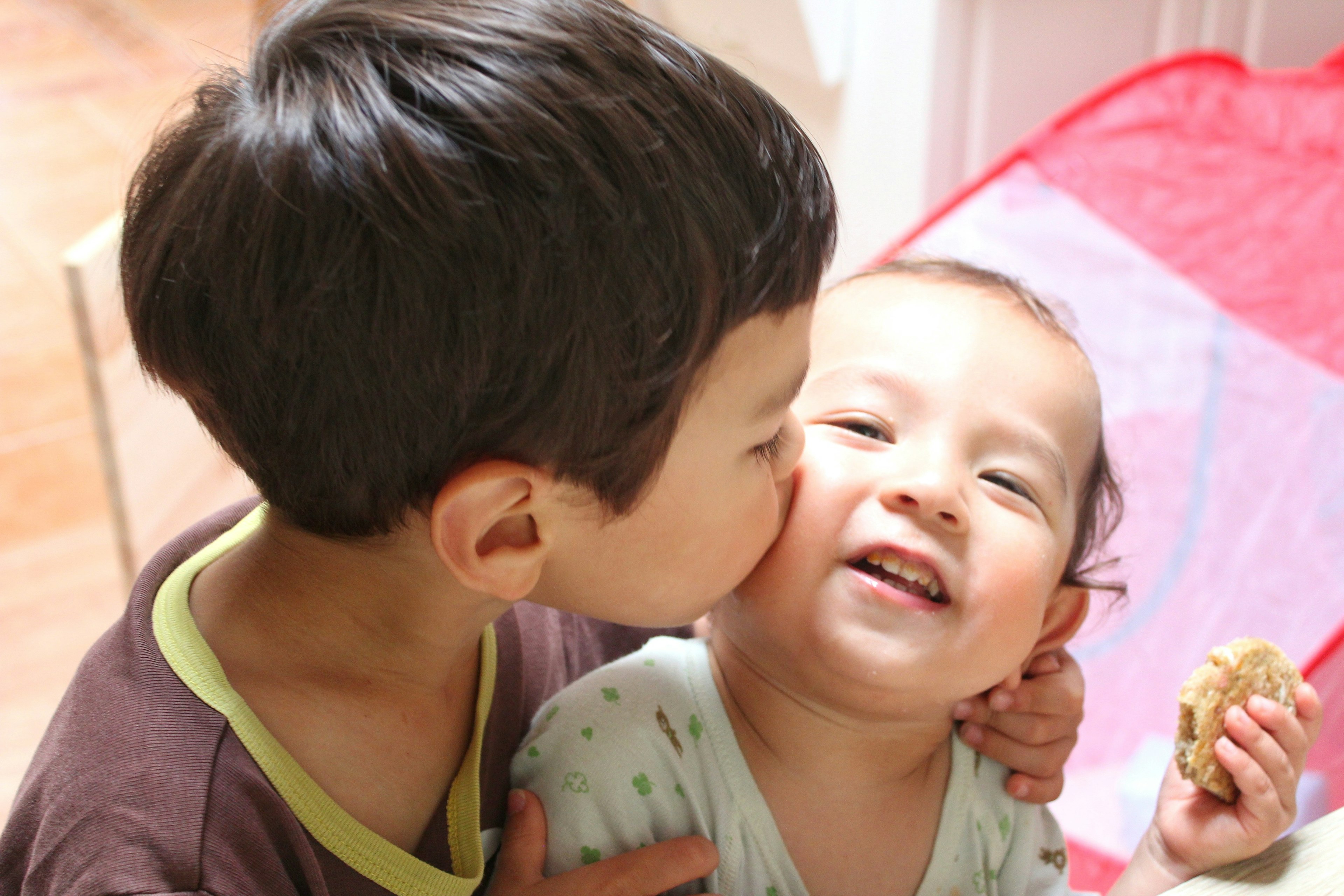 A warm moment of a brother kissing his sister