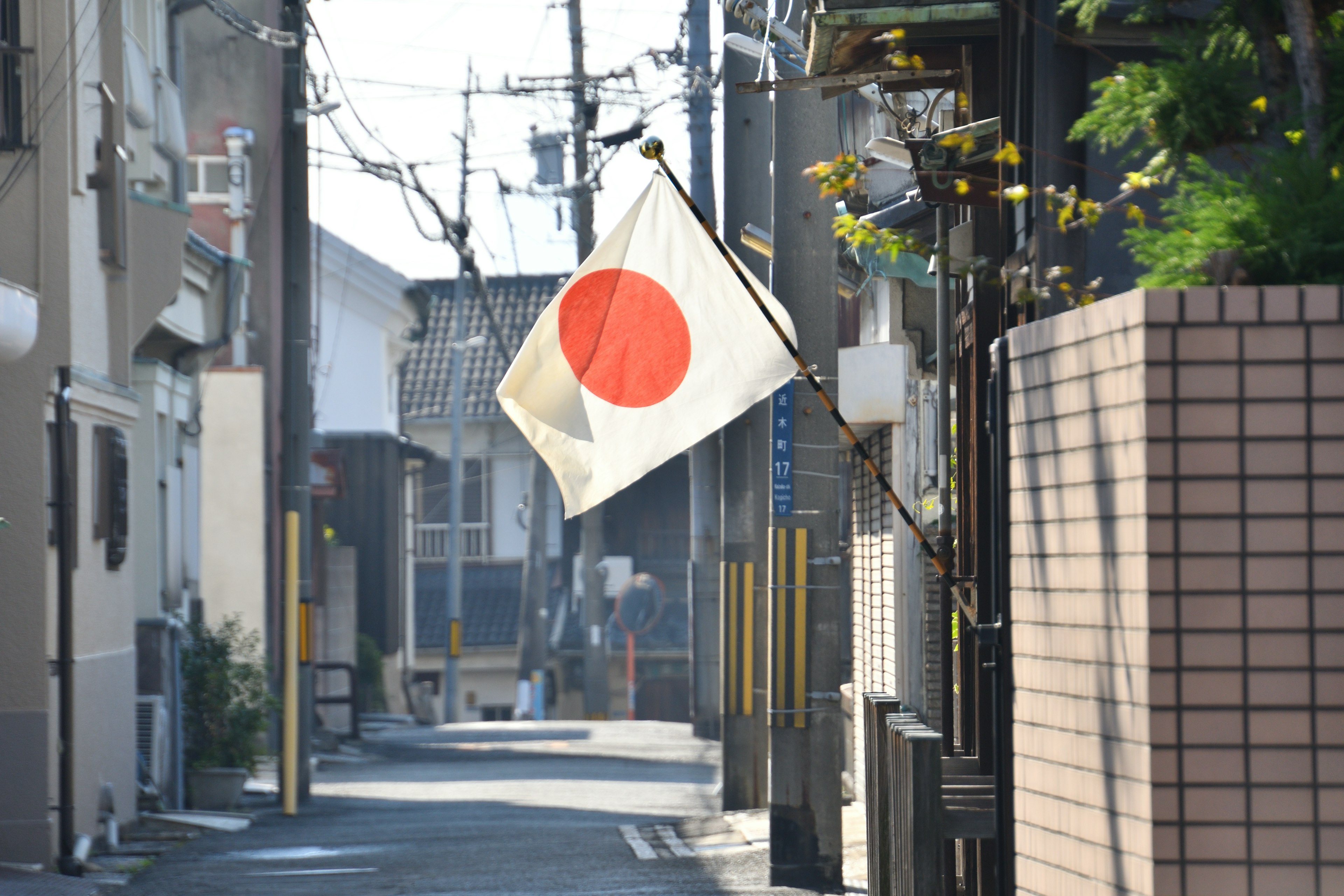 Quiet alley scene featuring the Japanese flag