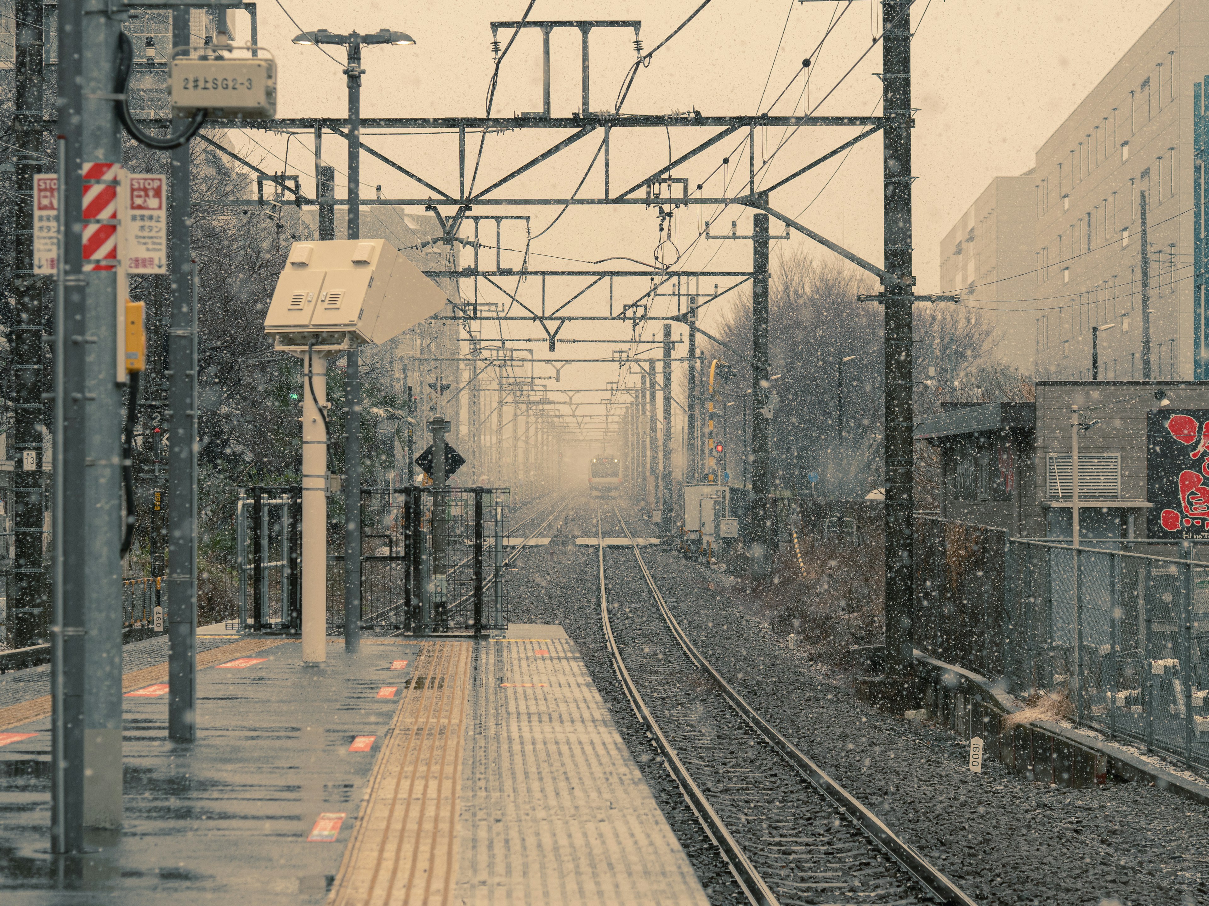 Snowy train station platform with railway tracks