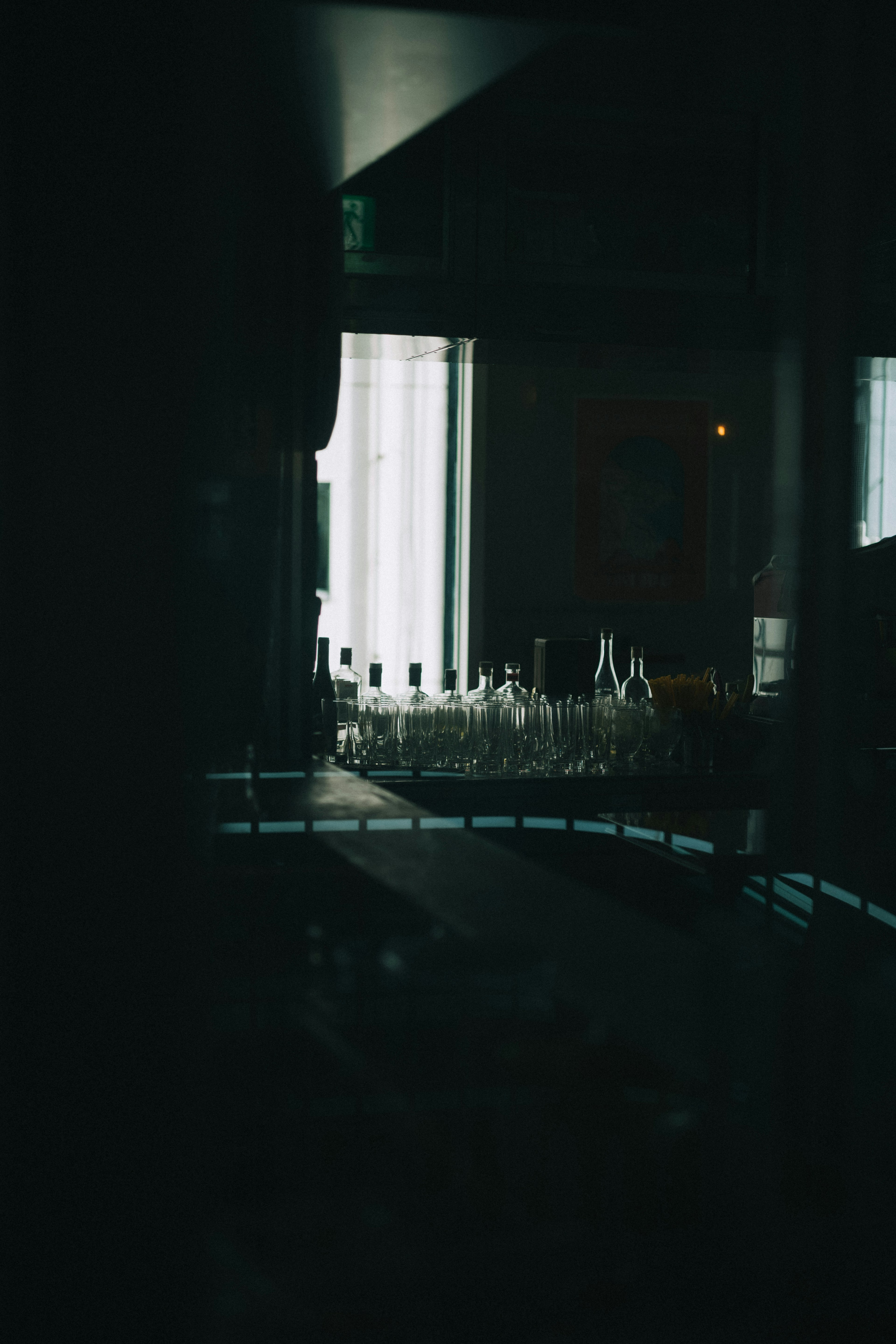 Interior de un bar débilmente iluminado con copas dispuestas