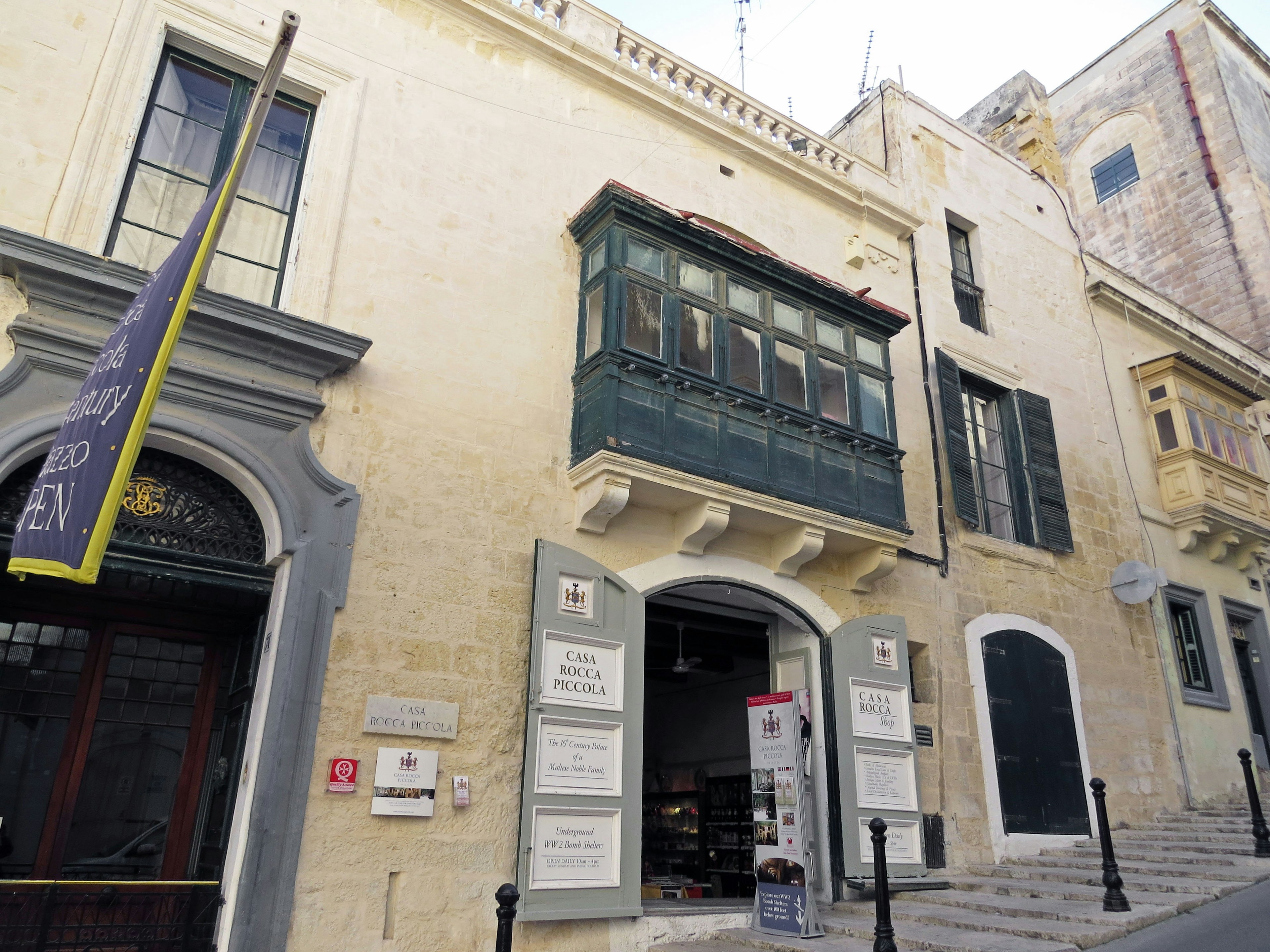 Historic building exterior featuring a green balcony with a stone pathway visible