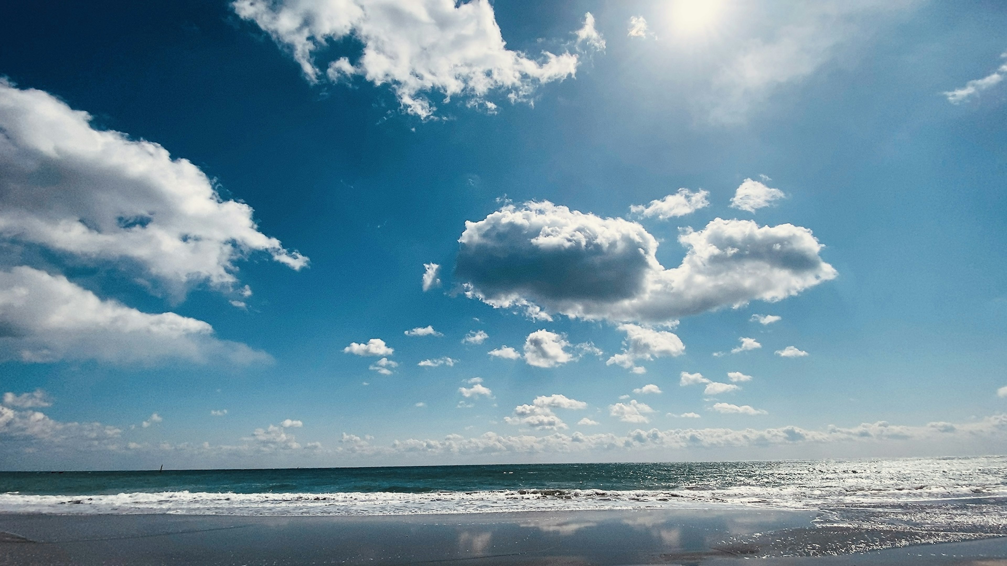 Ciel bleu avec des nuages blancs et vue sur l'océan