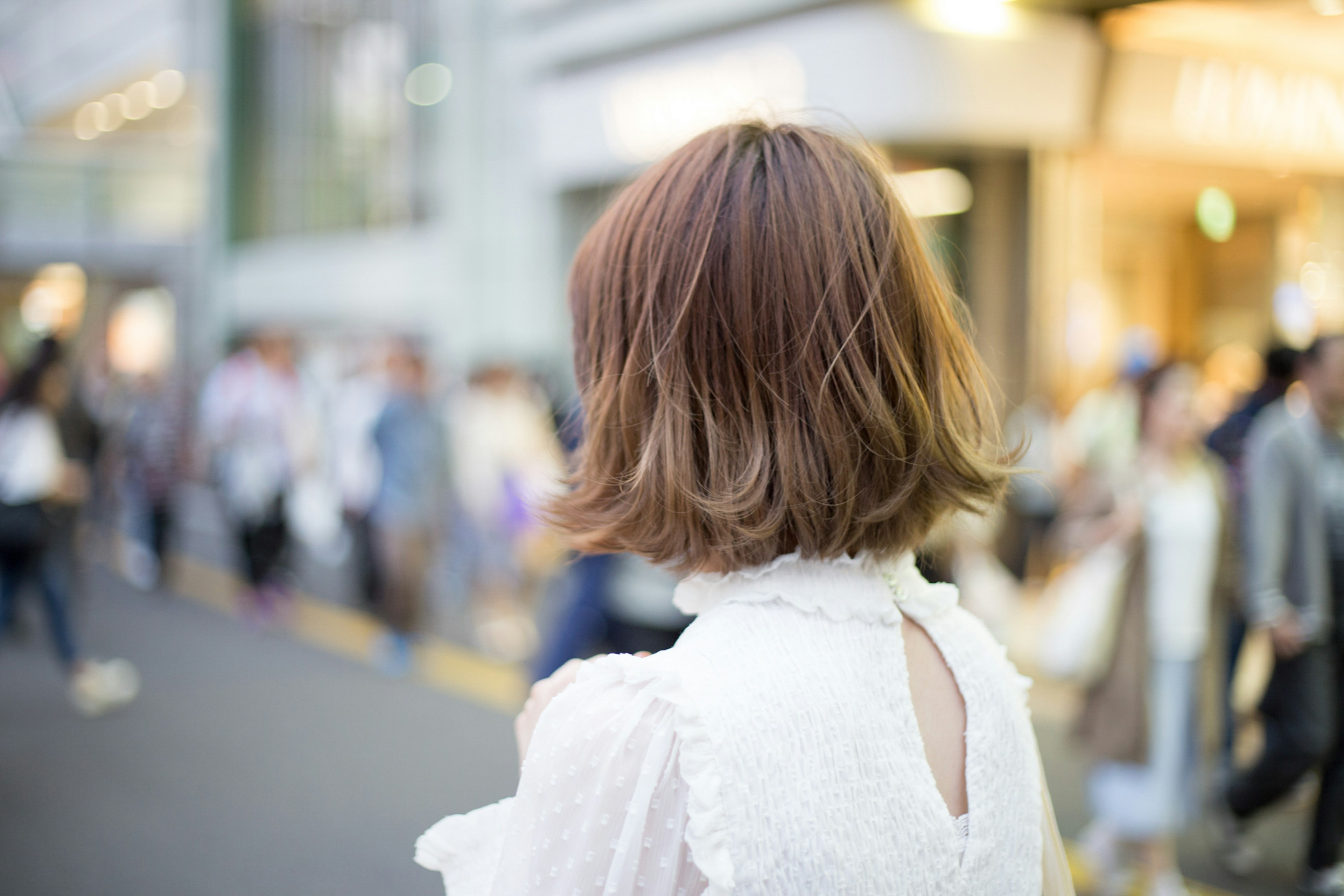 若い女性が白いドレスを着て後ろを向いている街の風景