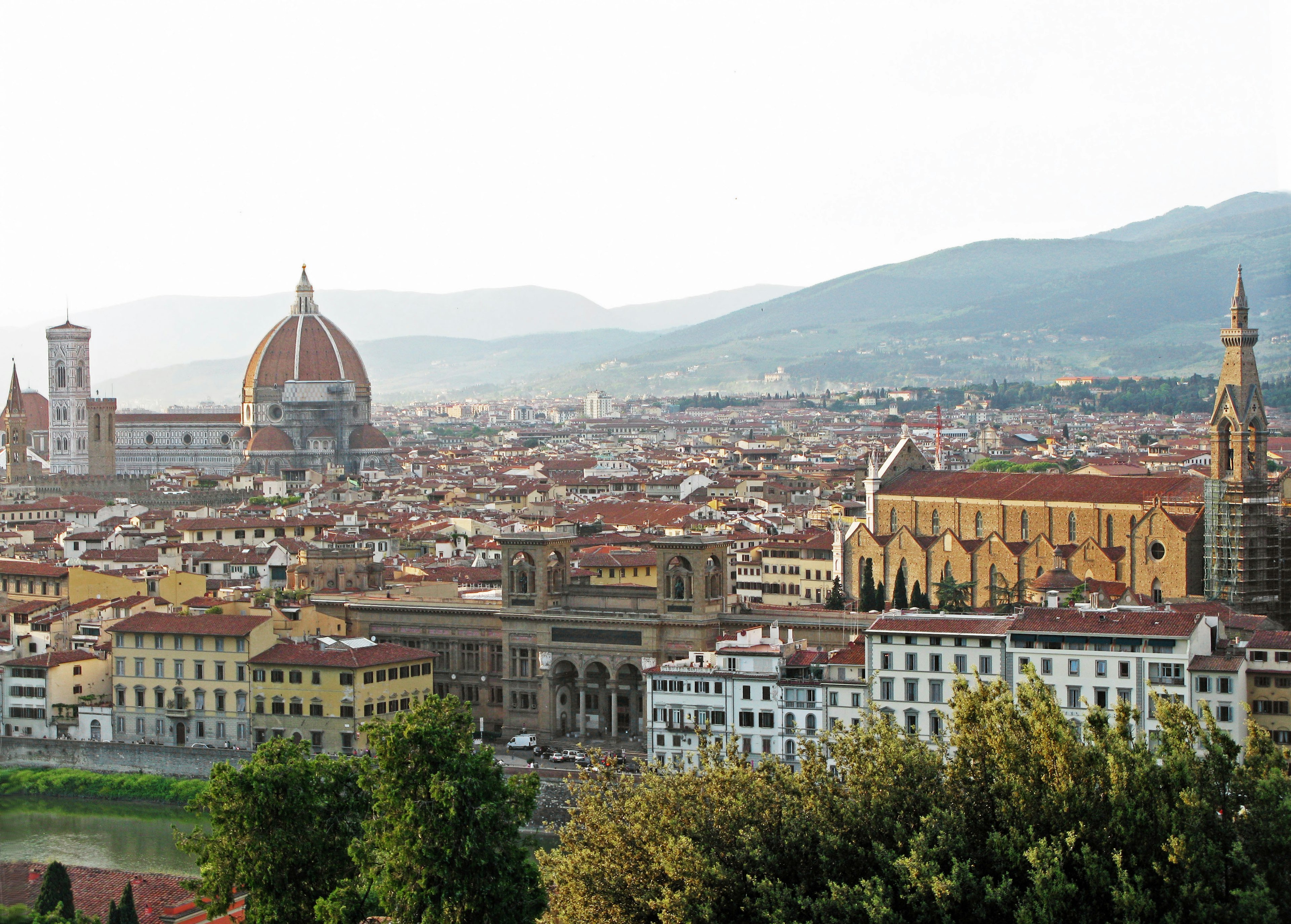 Panoramablick auf Florenz mit dem Duomo und historischen Gebäuden von einem grünen Hügel